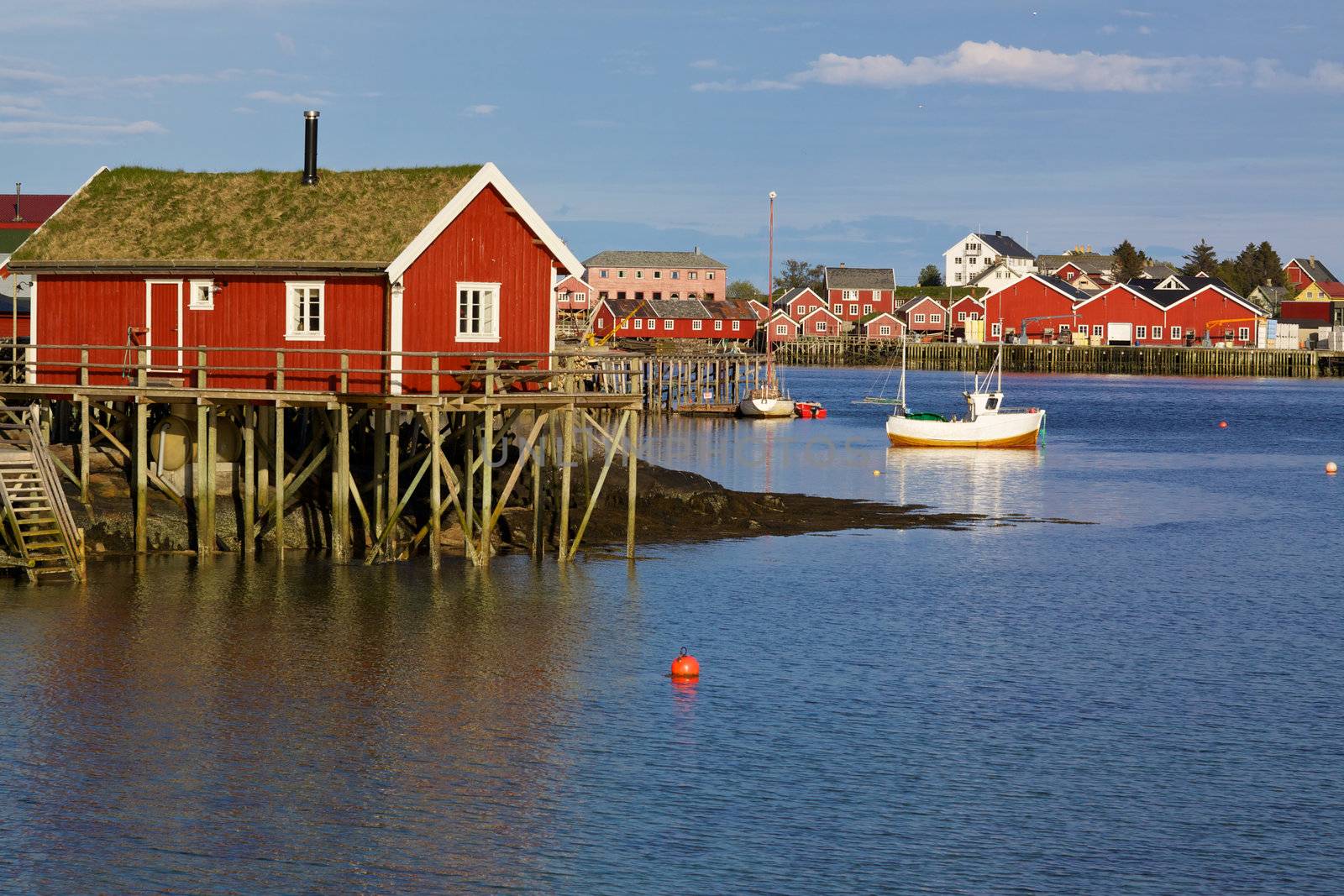 Traditional red rorbu hut with sod roof in town of Reine on Lofoten islands in Norway