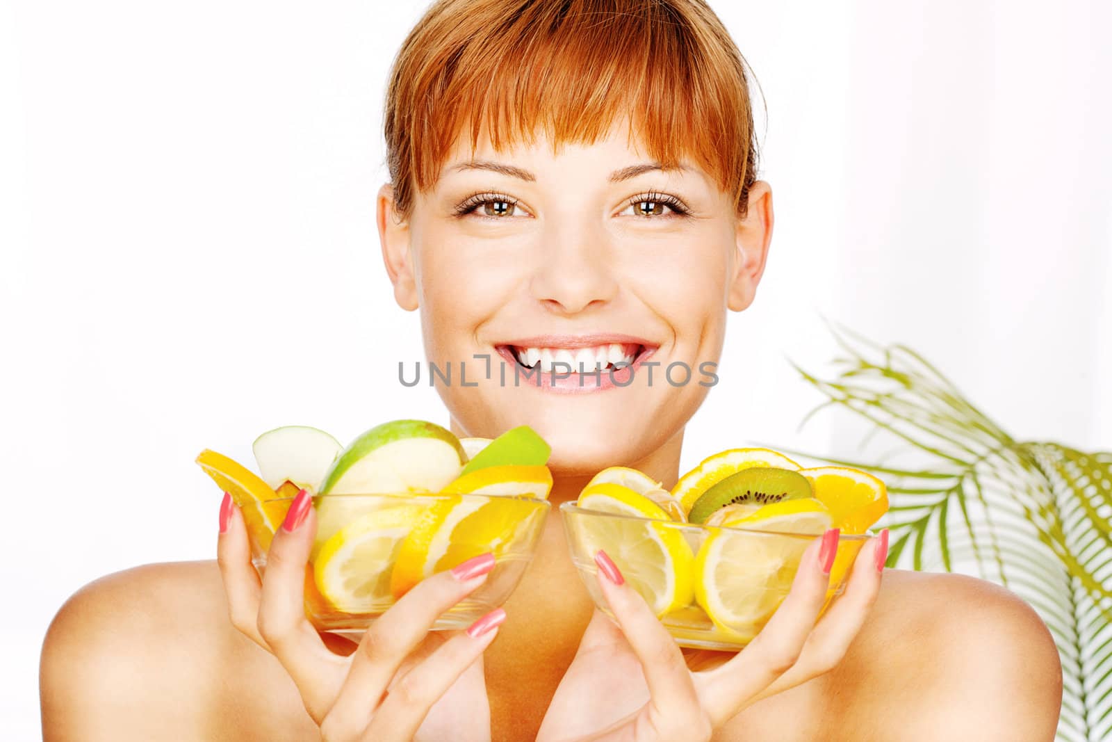 Portrait of a smiled girl with two bowl full of fruit in her hands