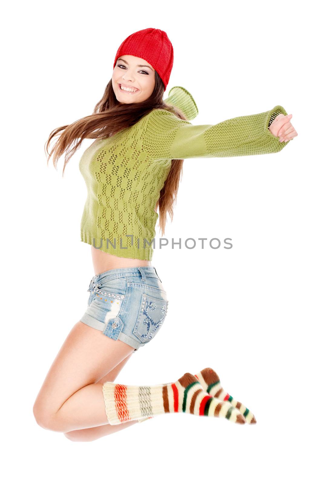 Happy brunette in wool sweater and wool socks jumping, isolated on white background