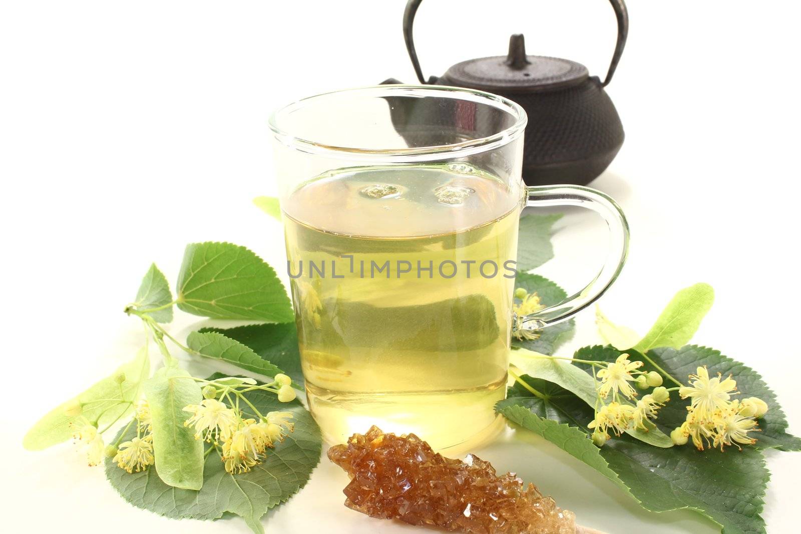 hot lime blossom tea with flowers and leaves on a light background