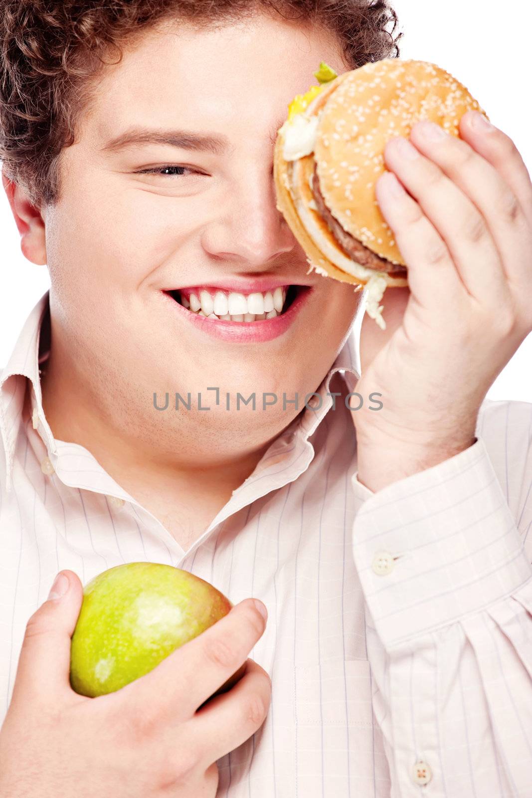 Young chubby man holding apple and hamburger, isolated on white