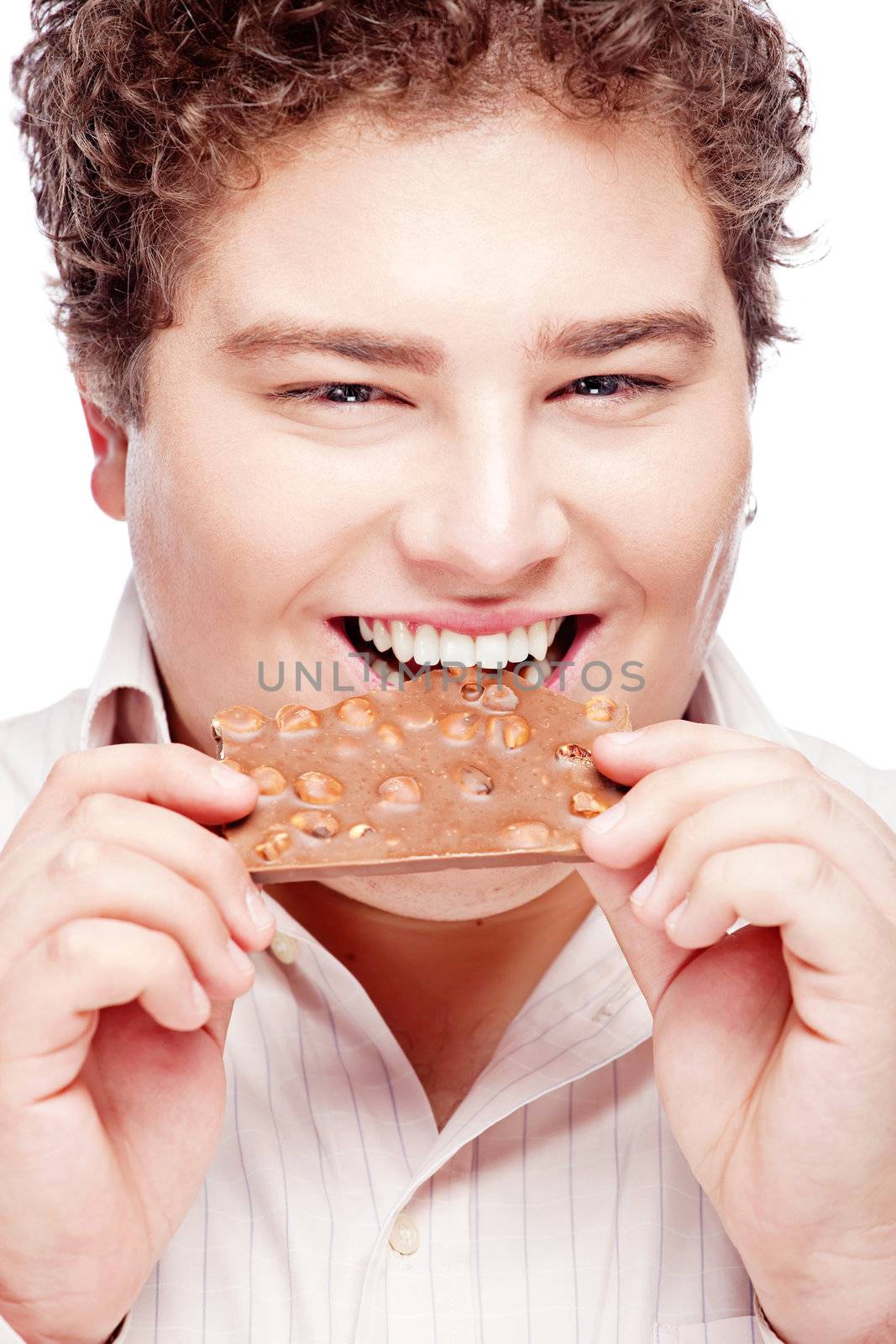 Happy chubby young man eating a slice of chocolate, isolated on white