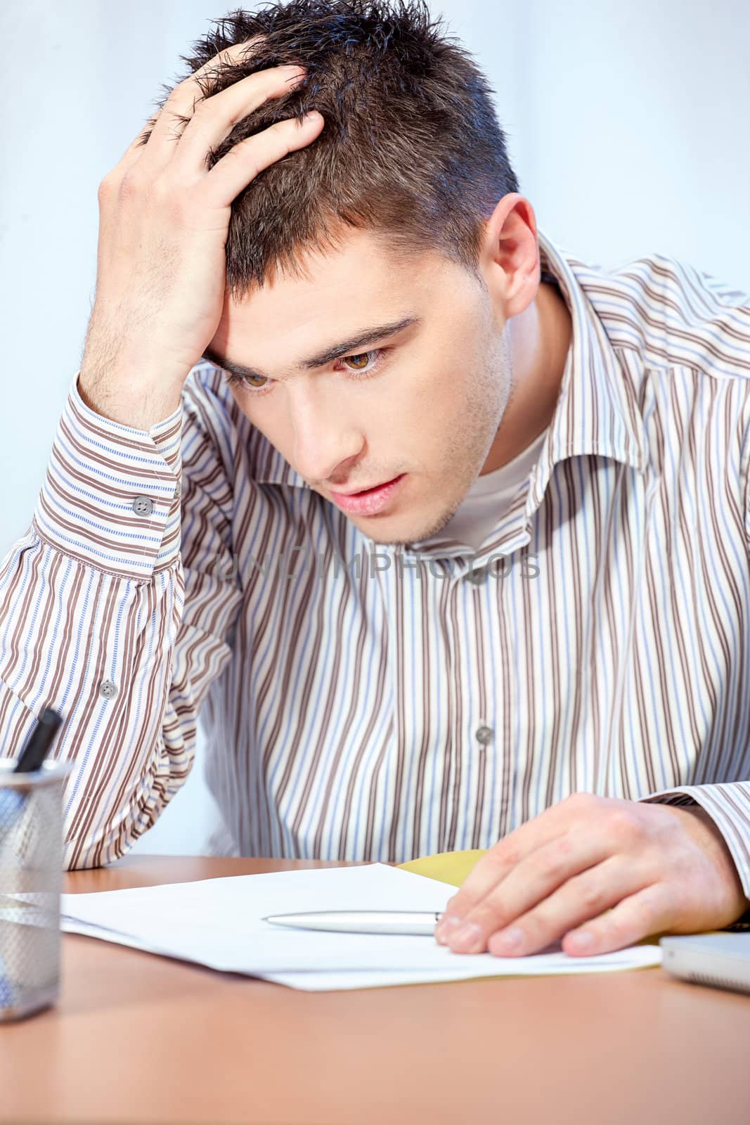 Worried young business man in office