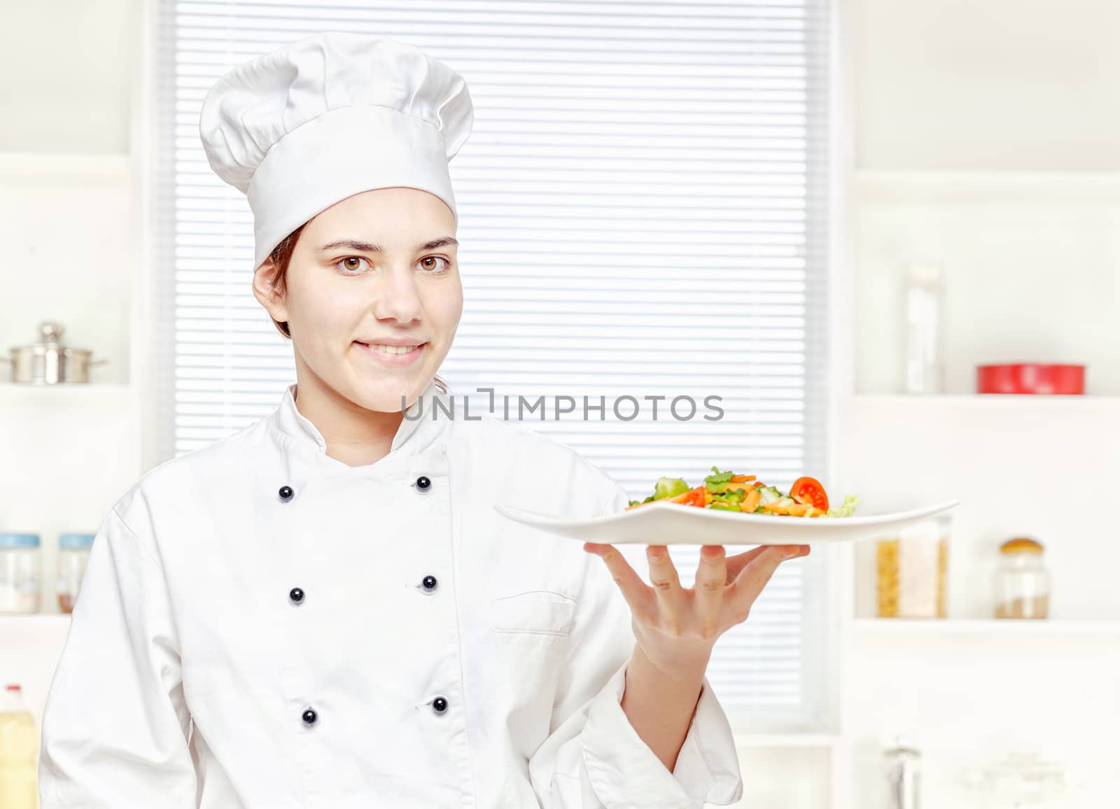 chef holding vegetarian meal in kitchen by imarin