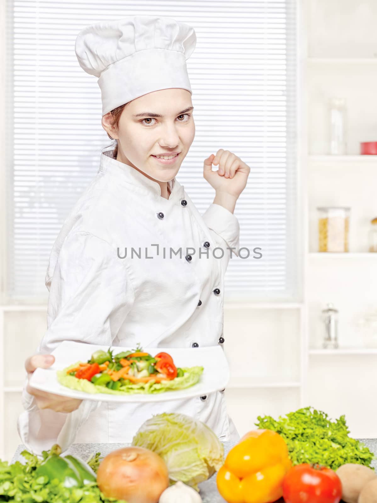 Young chef offering vegetarian meal in kitchen
