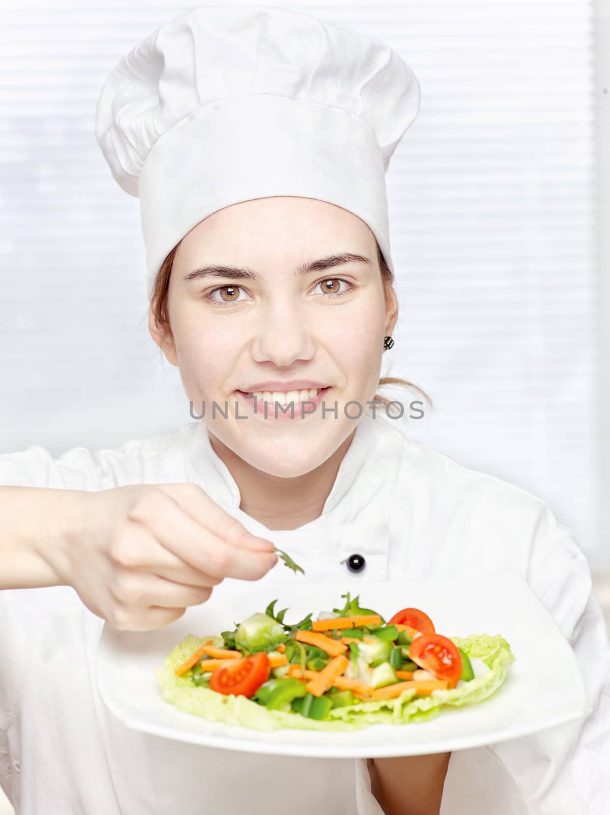 pretty young chef decorating delicious salad
