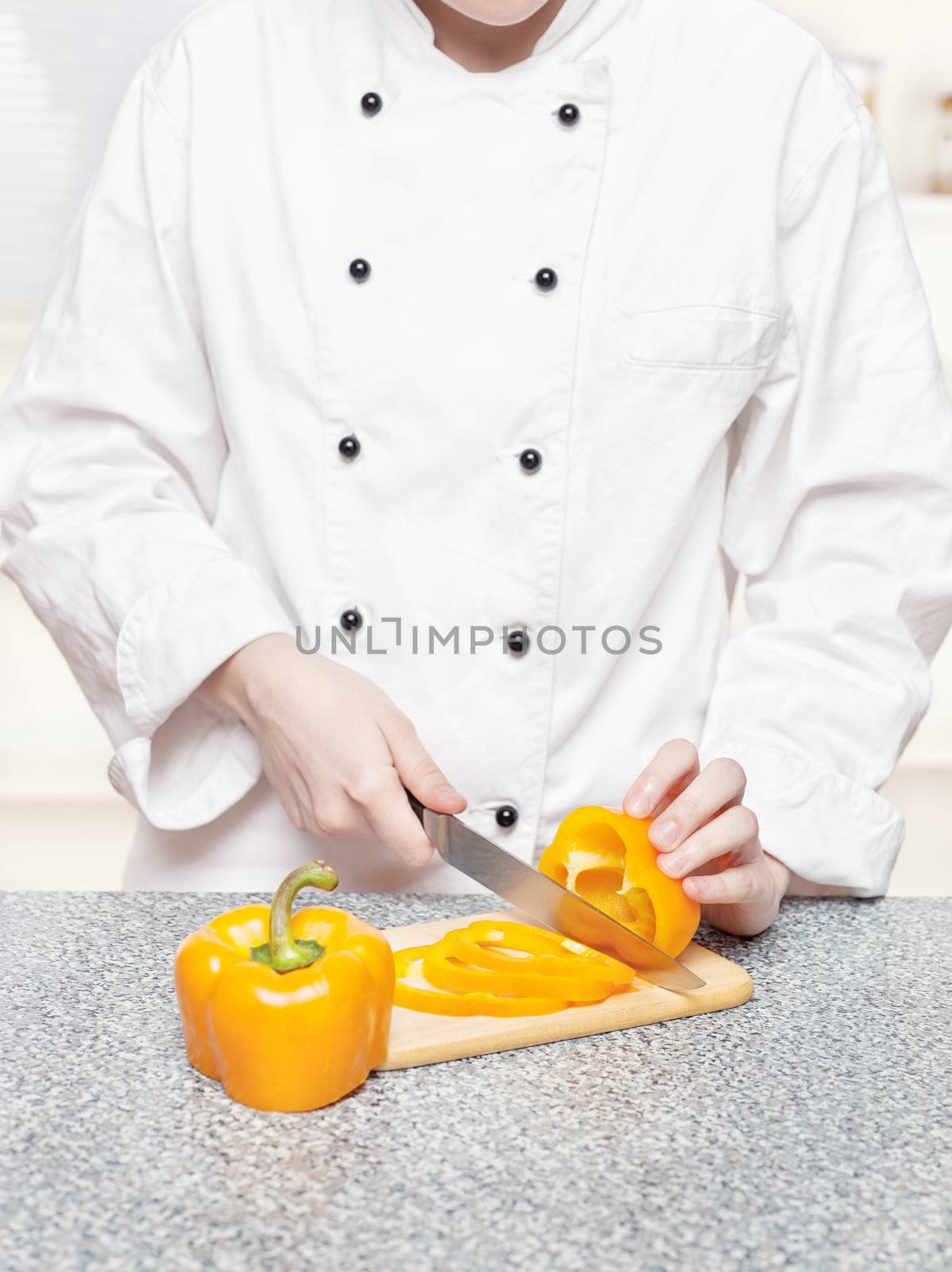 chef cutting bell peppers on board