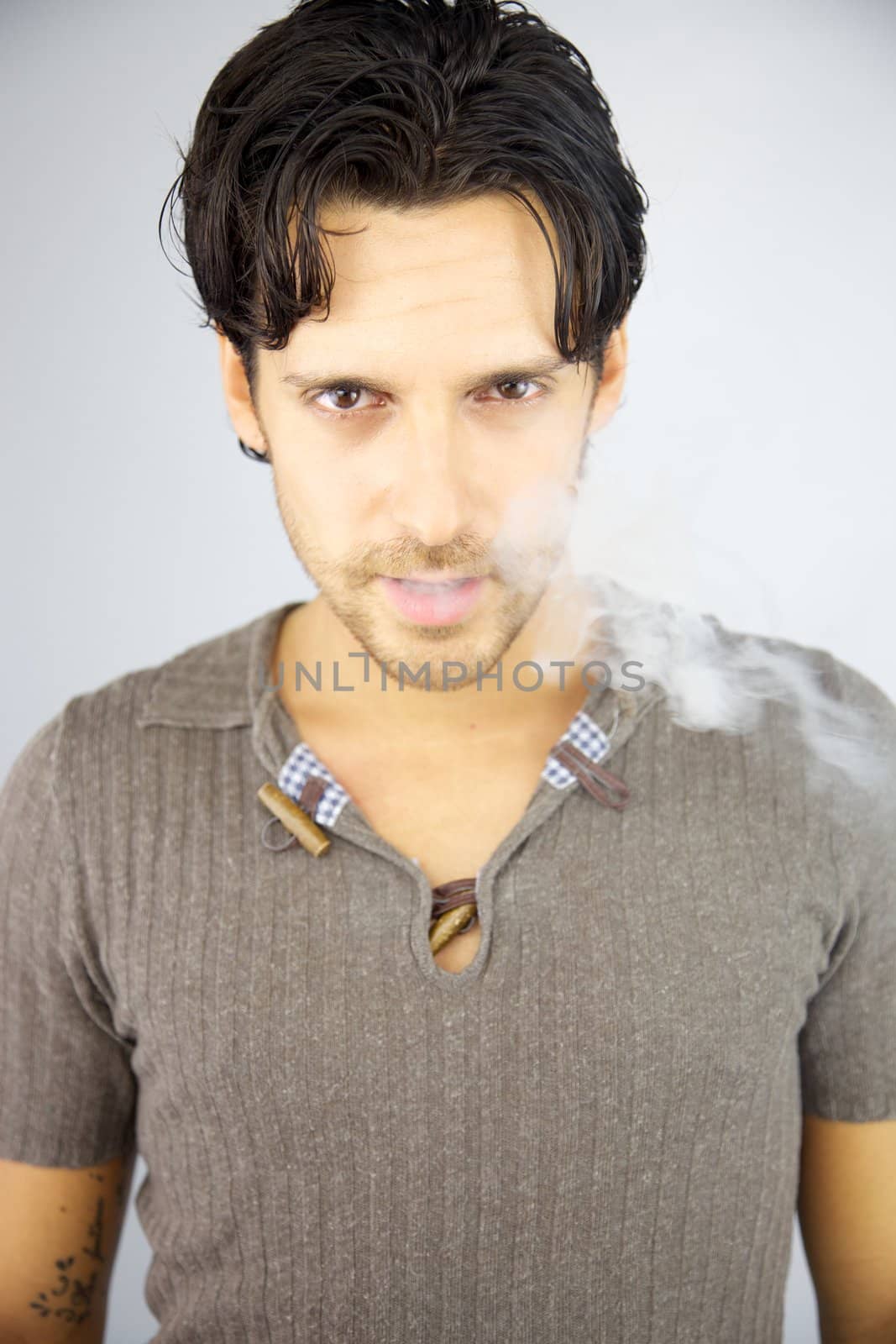 Handsome man with smoke coming out of his mouth by fmarsicano