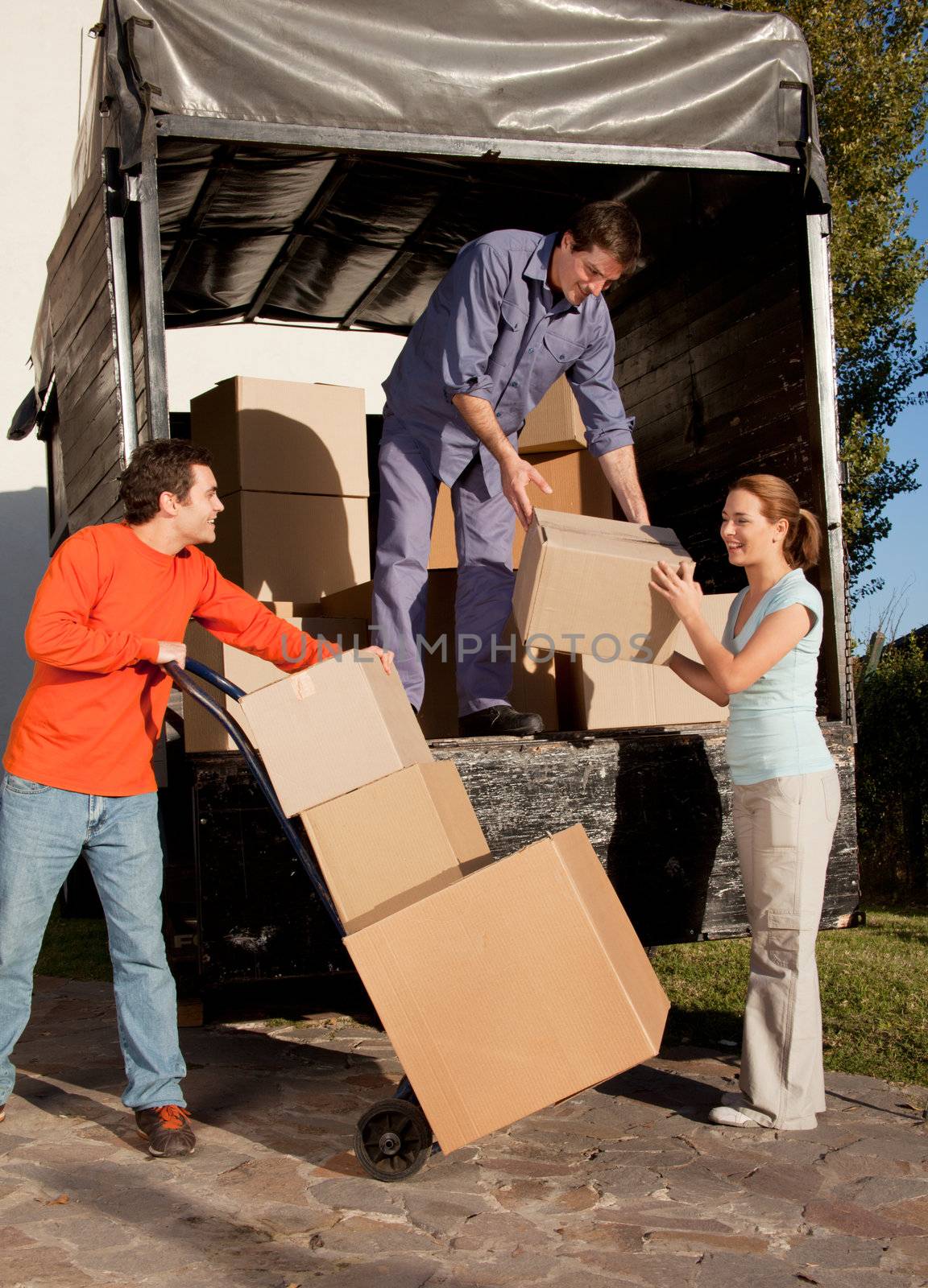 A group of people moving boxes from a trailer