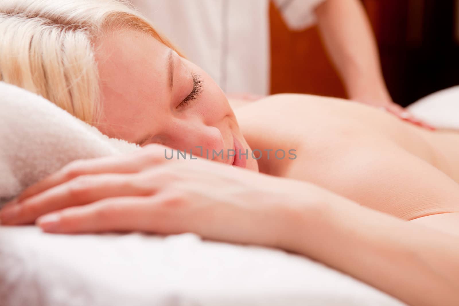 Detail of a relaxed woman receiving a back massage at a spa