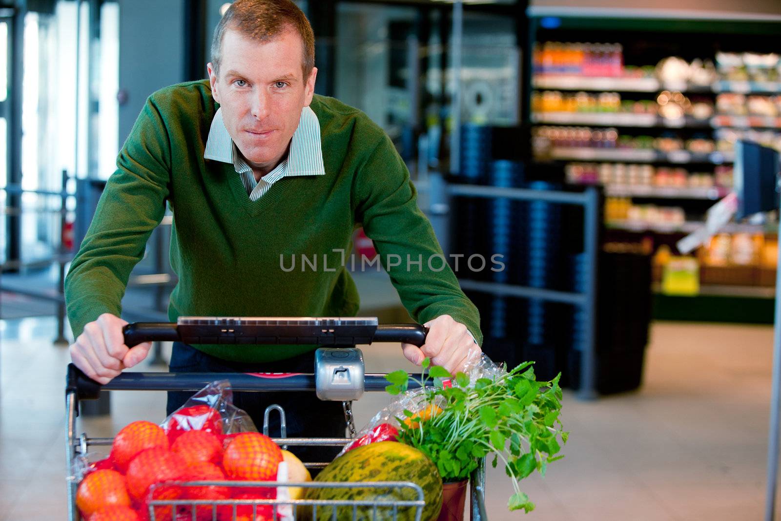 Portrait of a man pushing a grocery cart in a supermarket