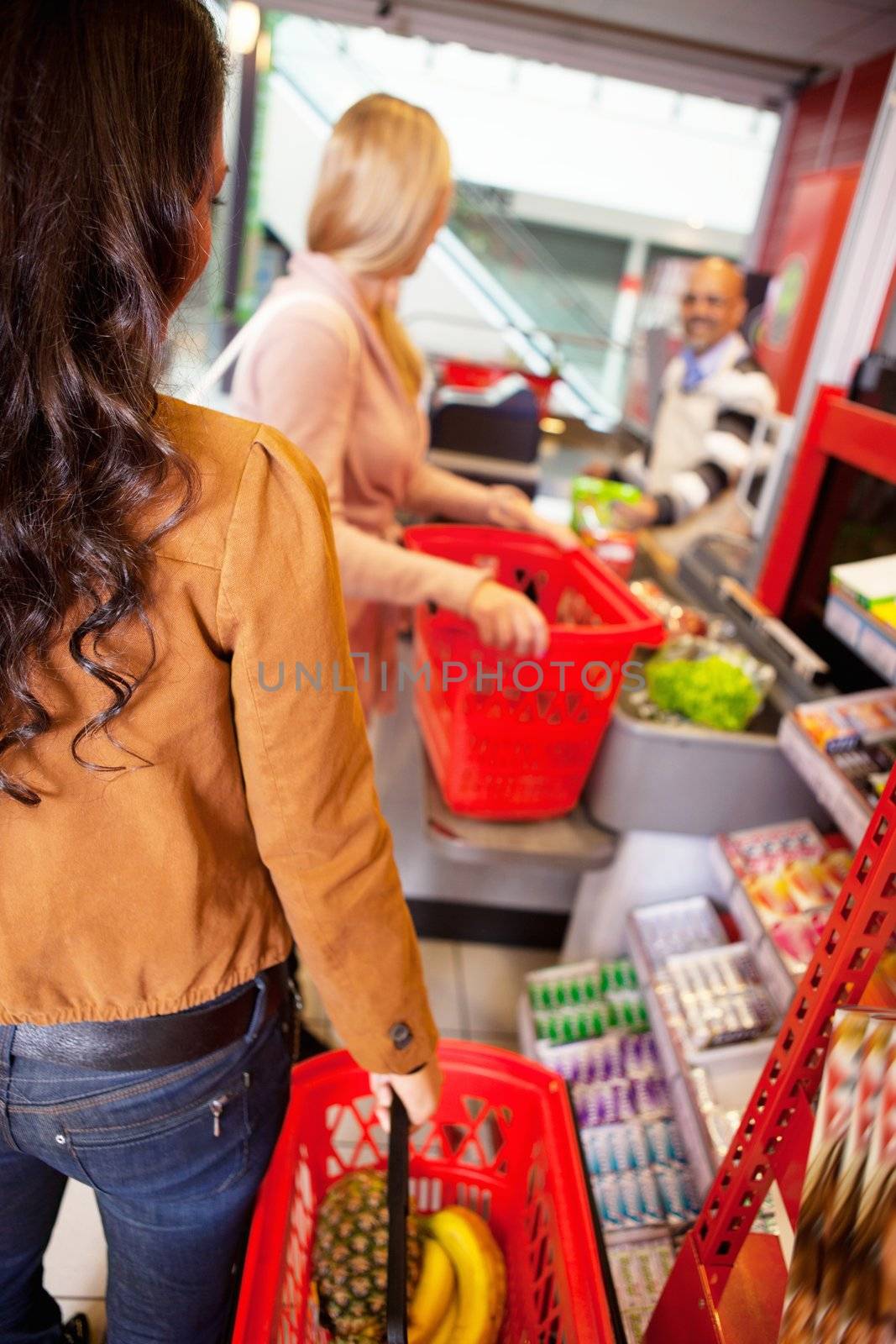 Customers carrying basket while shopping by leaf