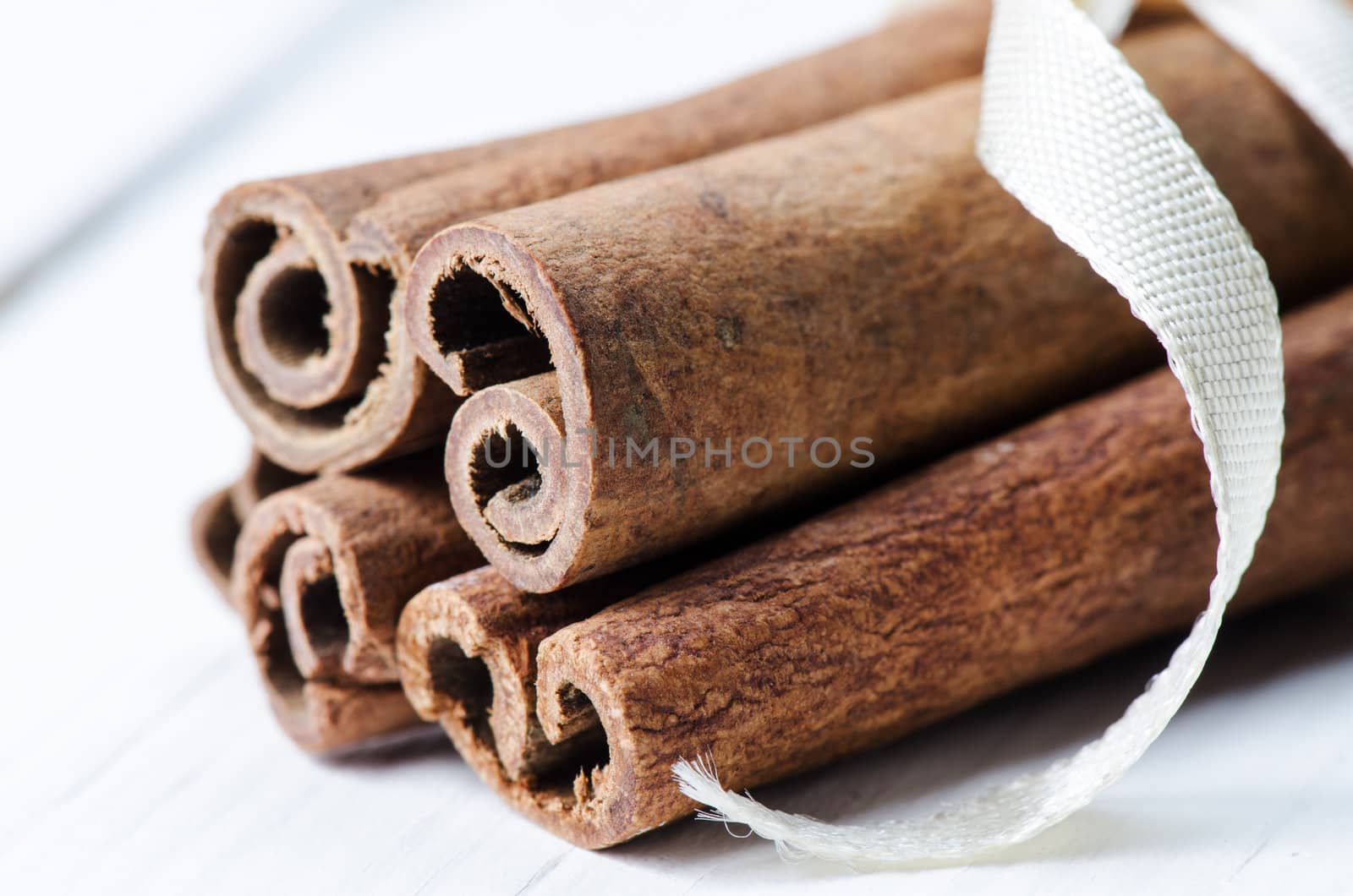 Close up tied with ribbon bunch cinnamon sticks by Nanisimova