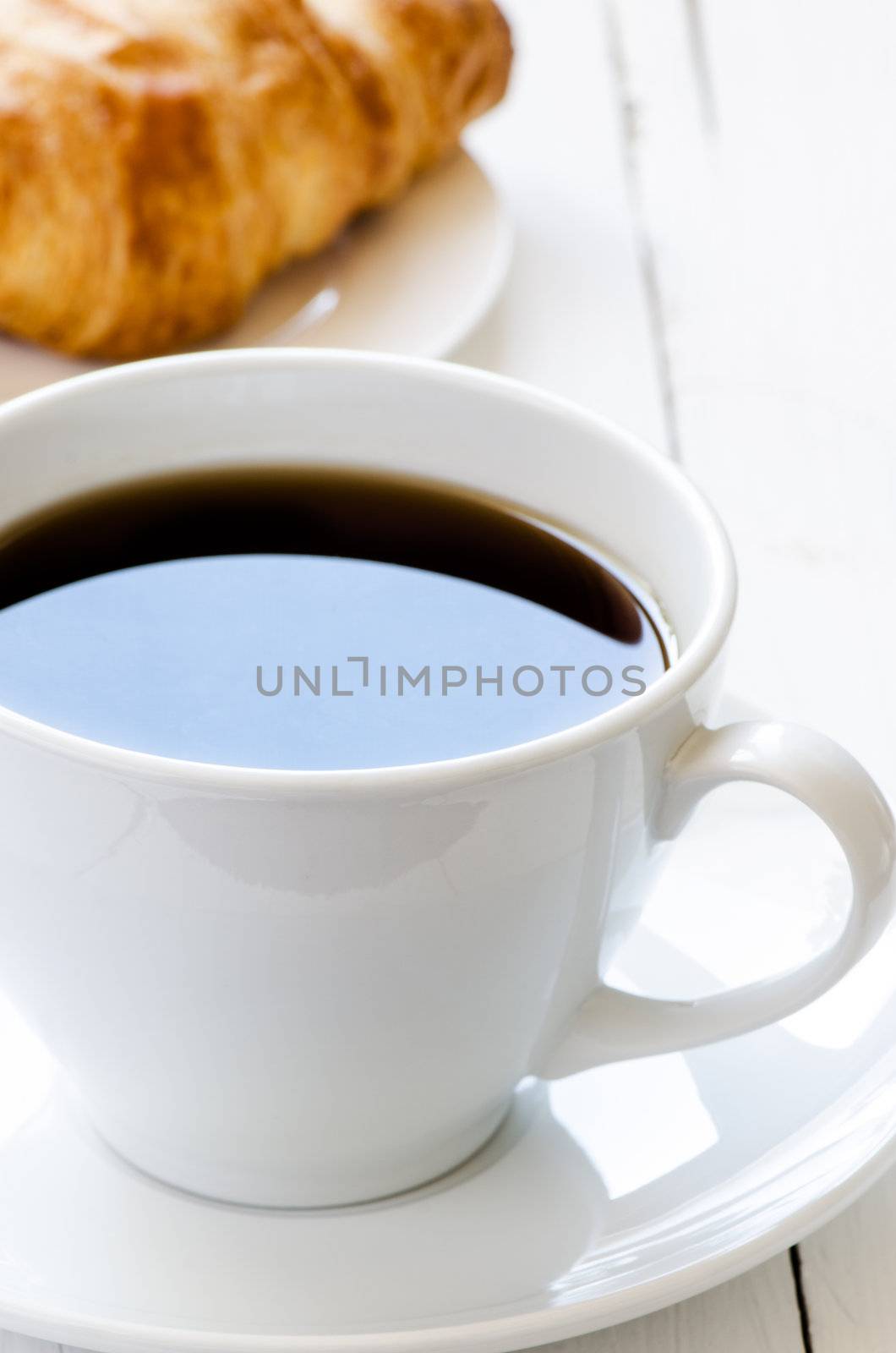 Cup  coffee and croissant on background