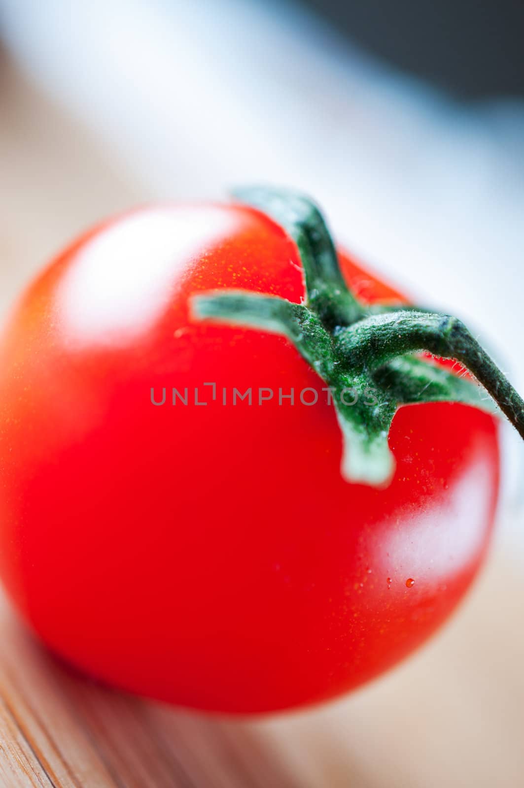 Tomato on  wooden board by Nanisimova