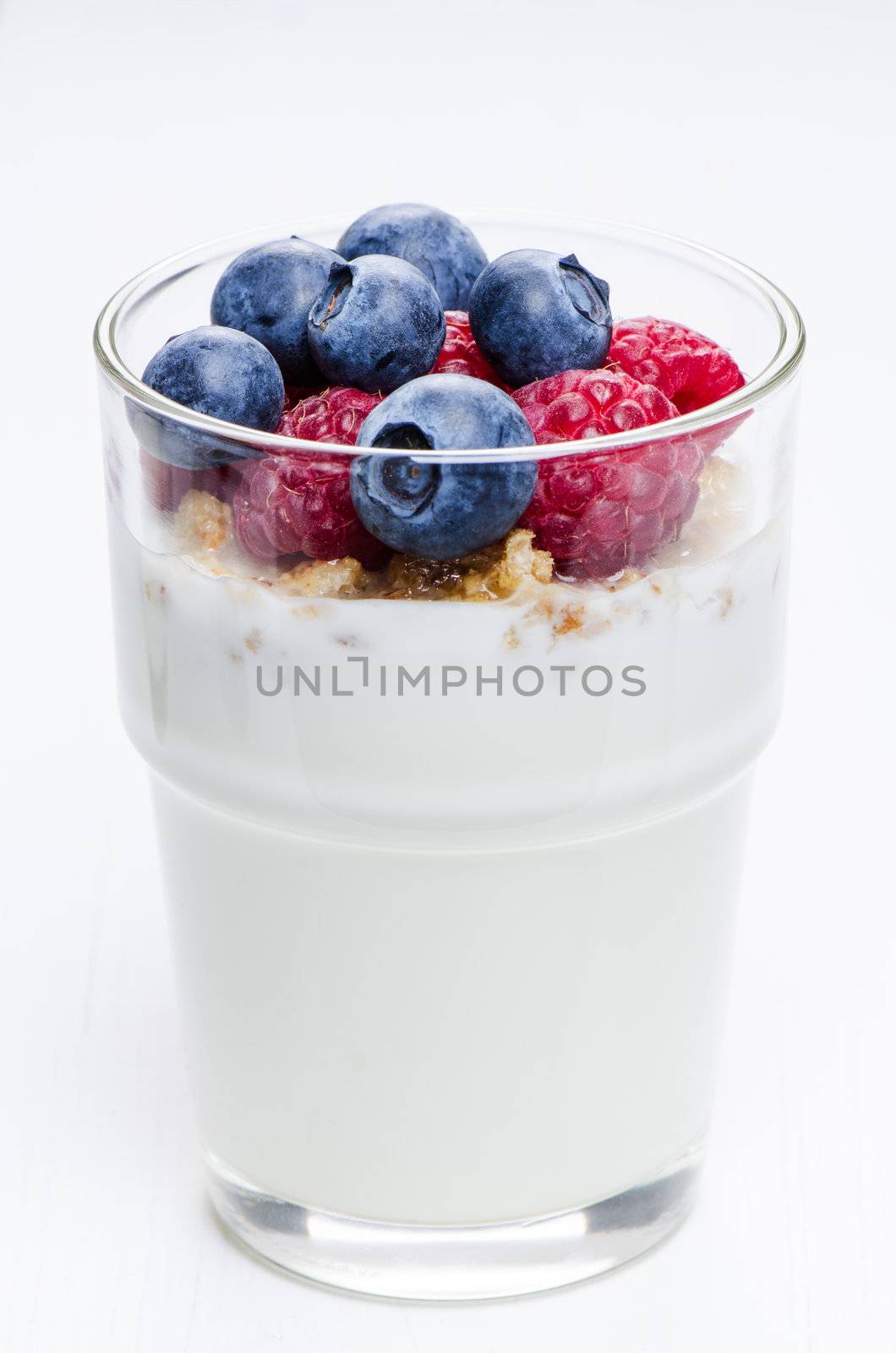 Yogurt with raspberries and blueberries in glass