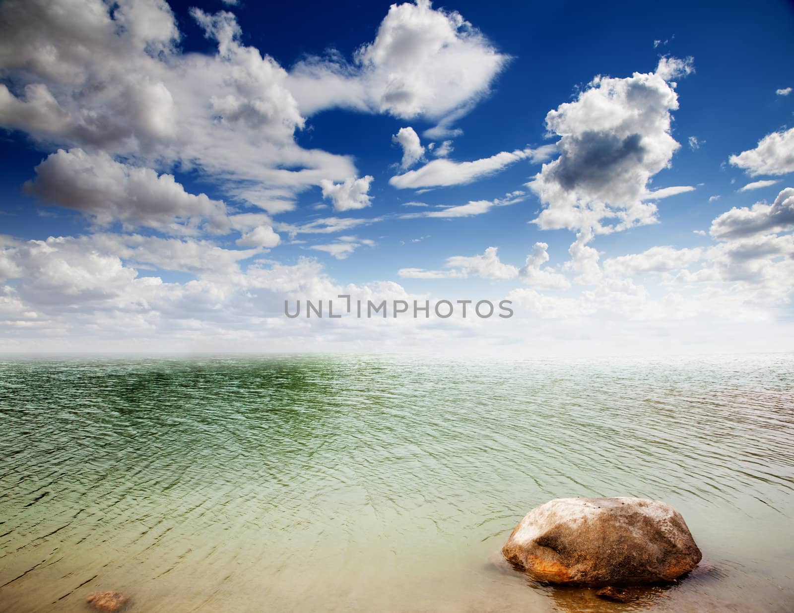 Colorful dramatic landscape with water,stone and cloudy sky