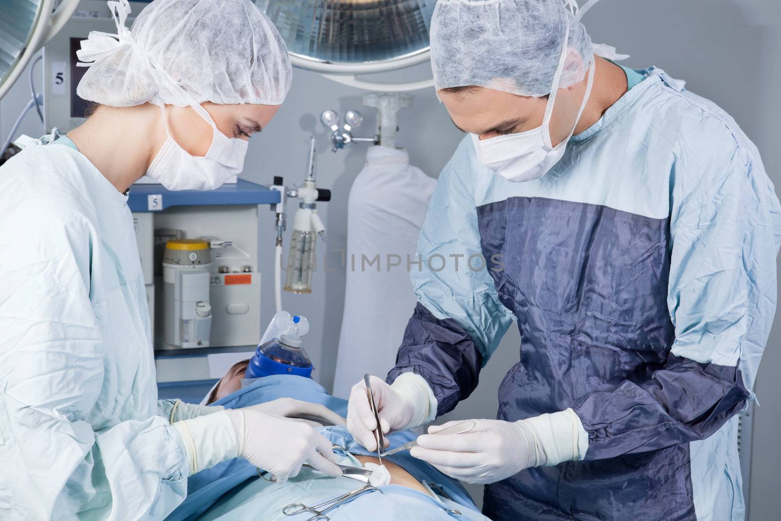 Medical professionals carrying on surgery on patient by leaf