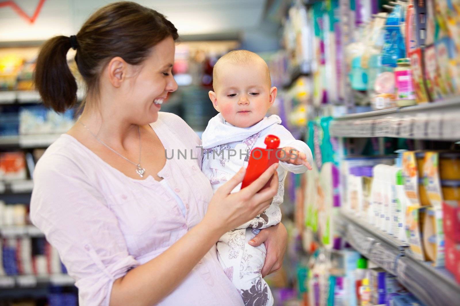 Cheerful mother playing with baby and spending time in shopping store