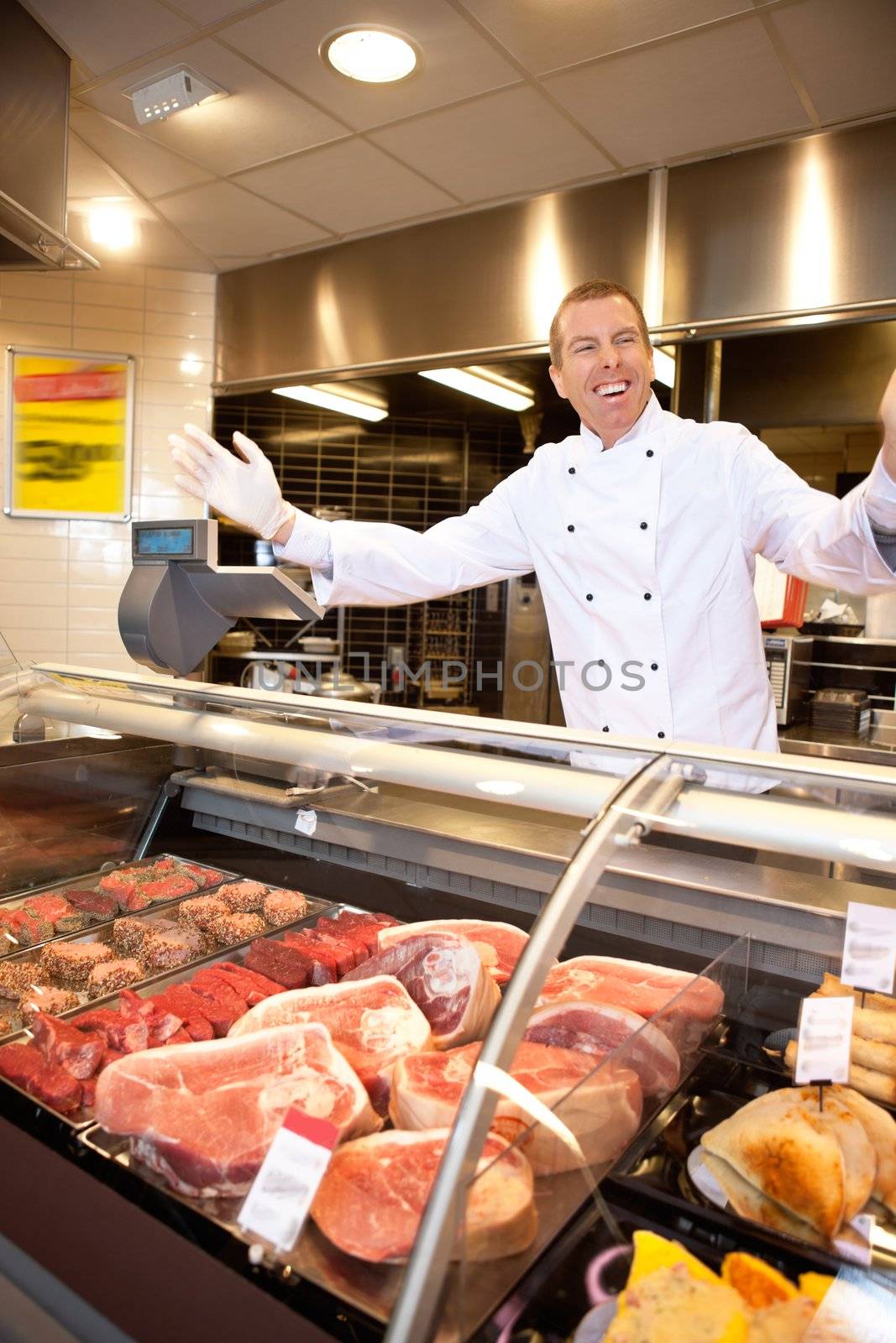 Fresh meat counter with happy butcher serving customers
