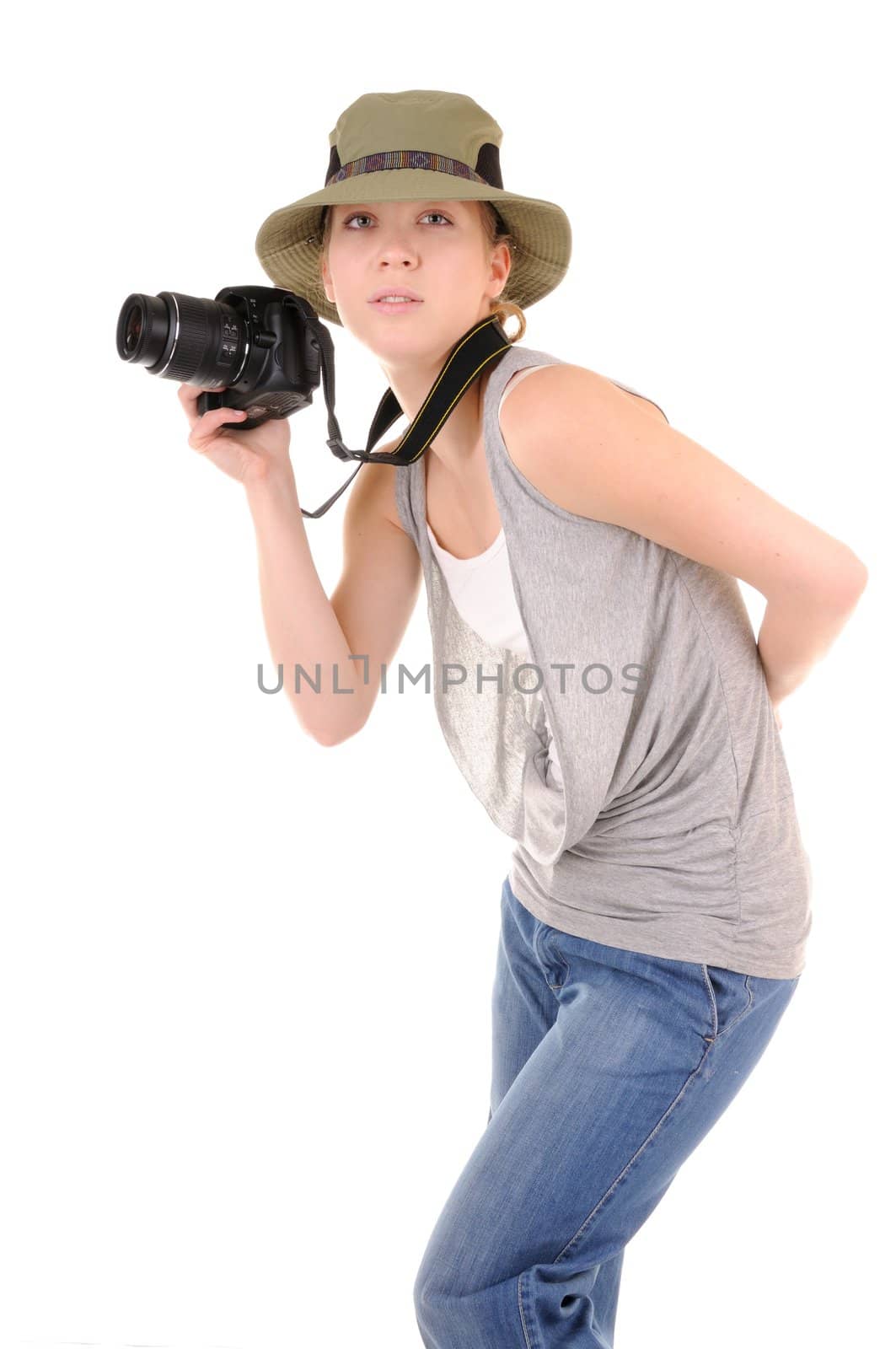 Casual smiling girl-tourist in jeans with professional digital photocamera is looking for picture isolated on white background