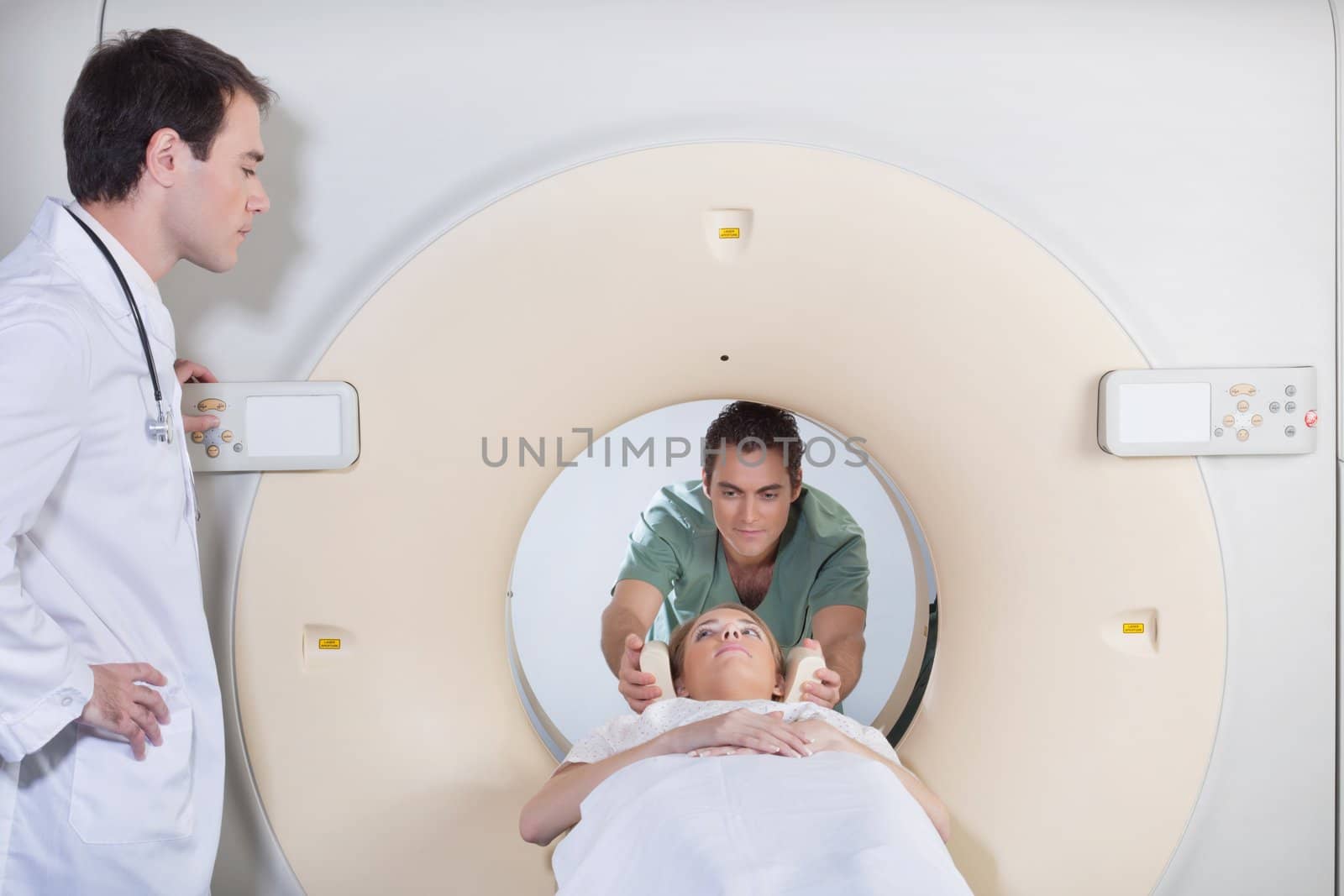 Male nurse preparing patient for CT scan