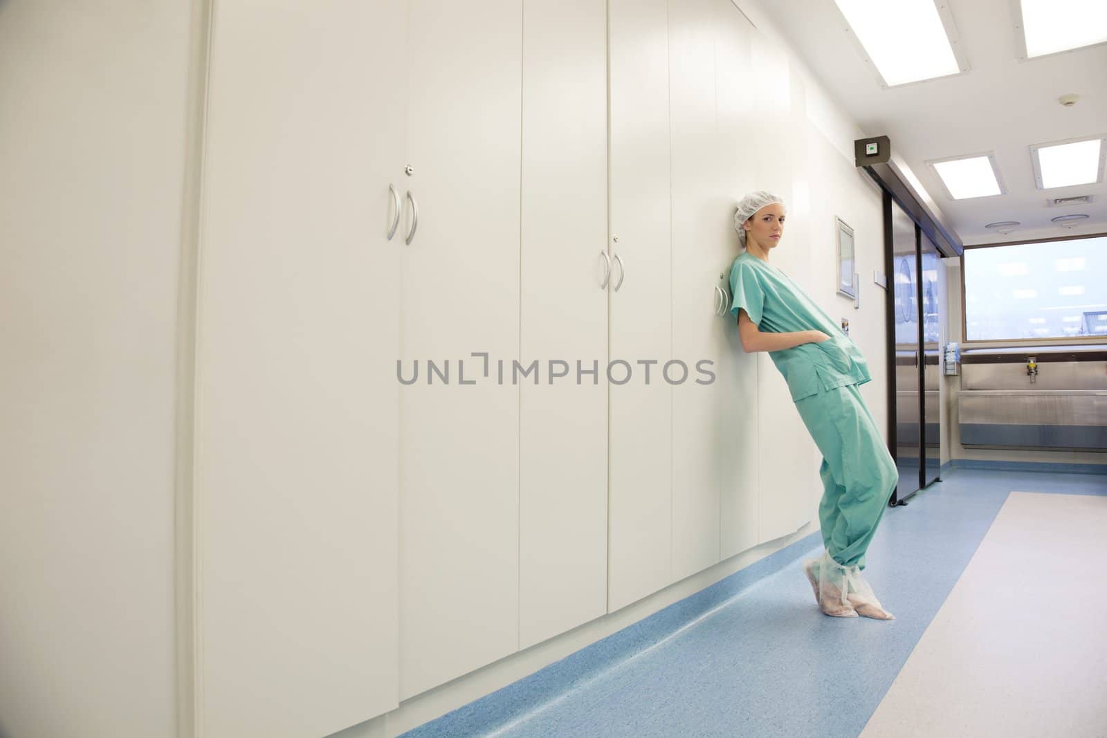 Young female doctor or nurse standing in hospital corridor