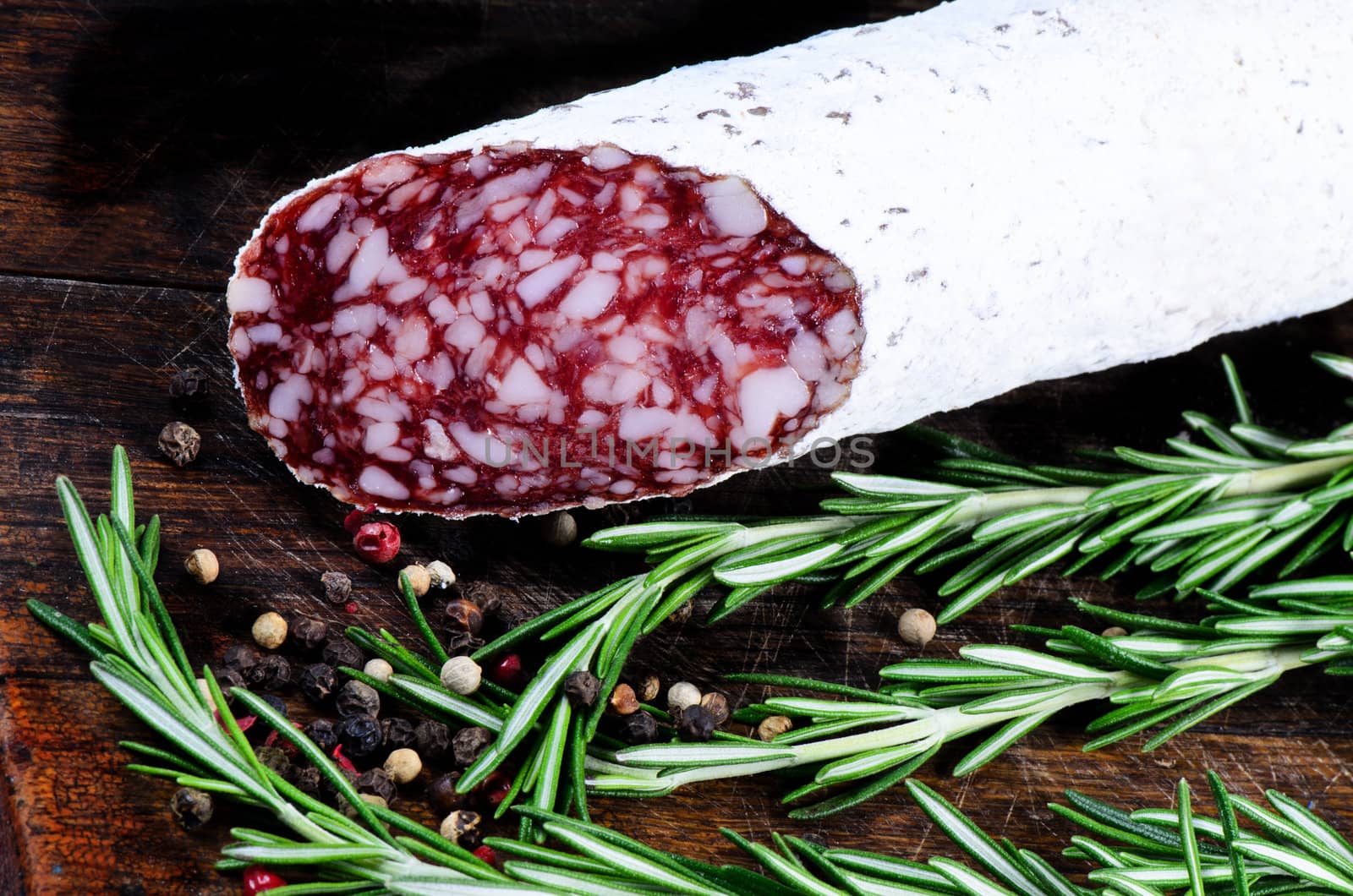 Salami and peper corns with rosemary on cutting board