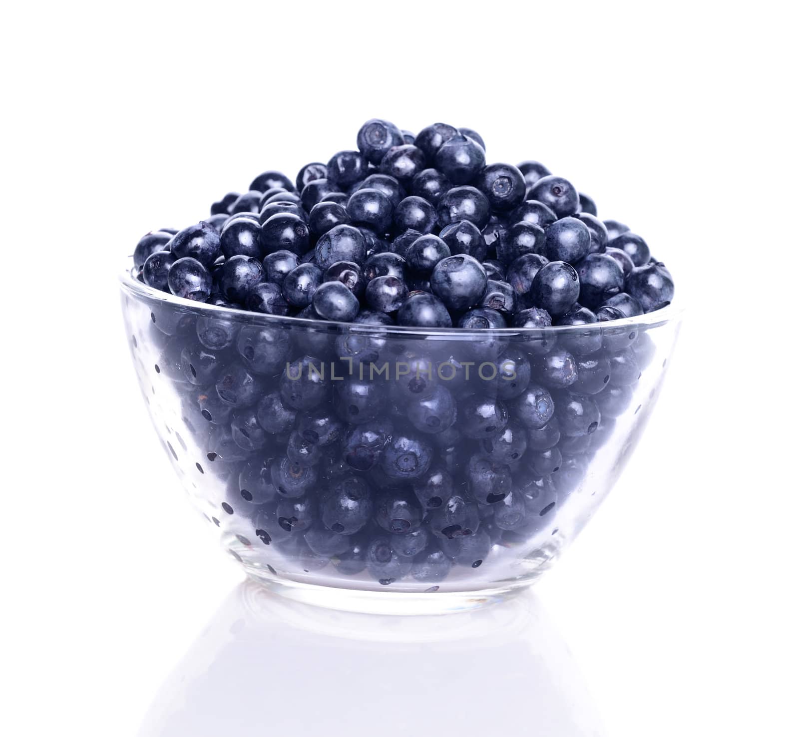 Blueberries in transparent glass dish with soft shadow on white background