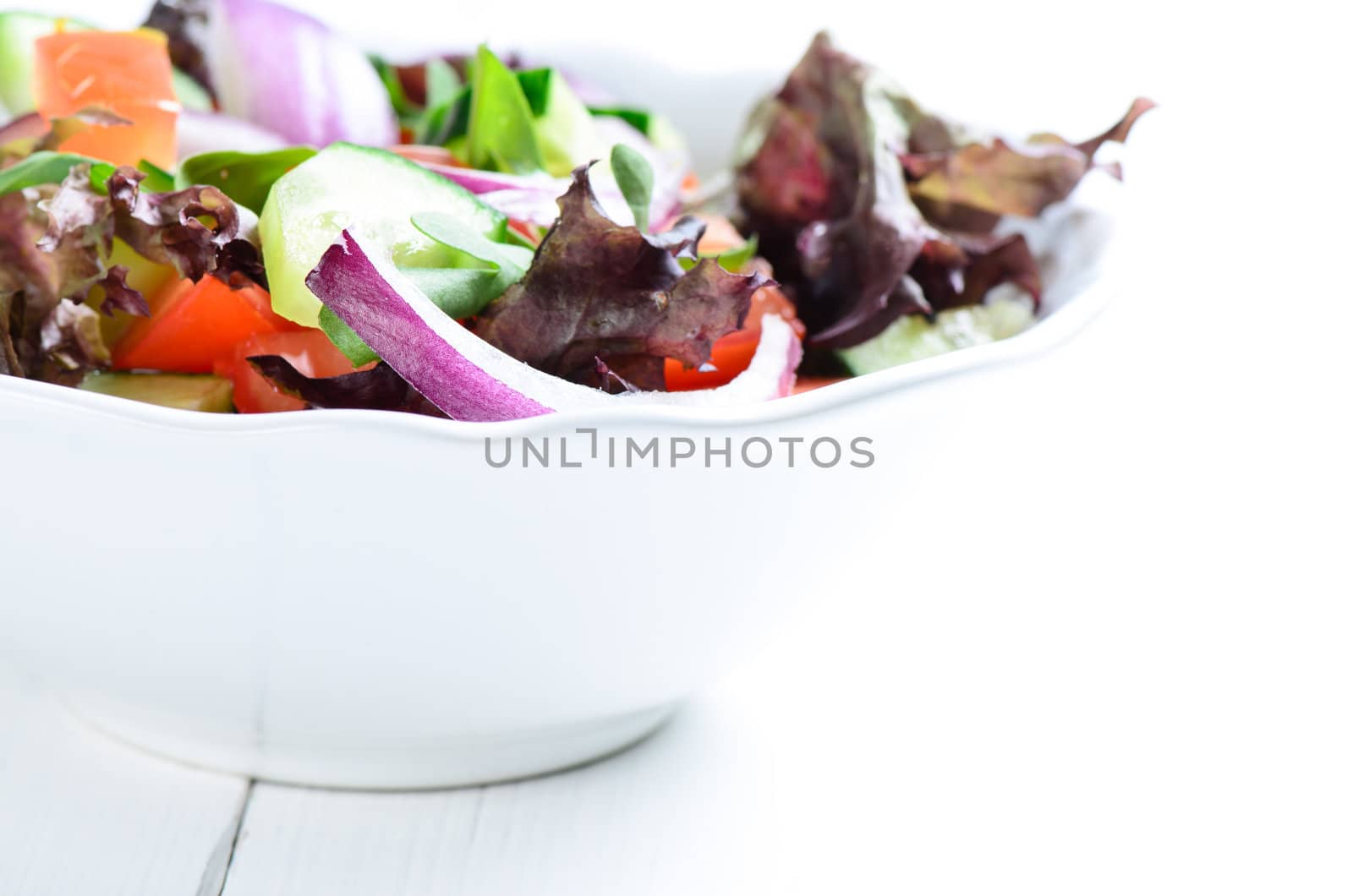 Vegetable Salad in white bowl on wooden table