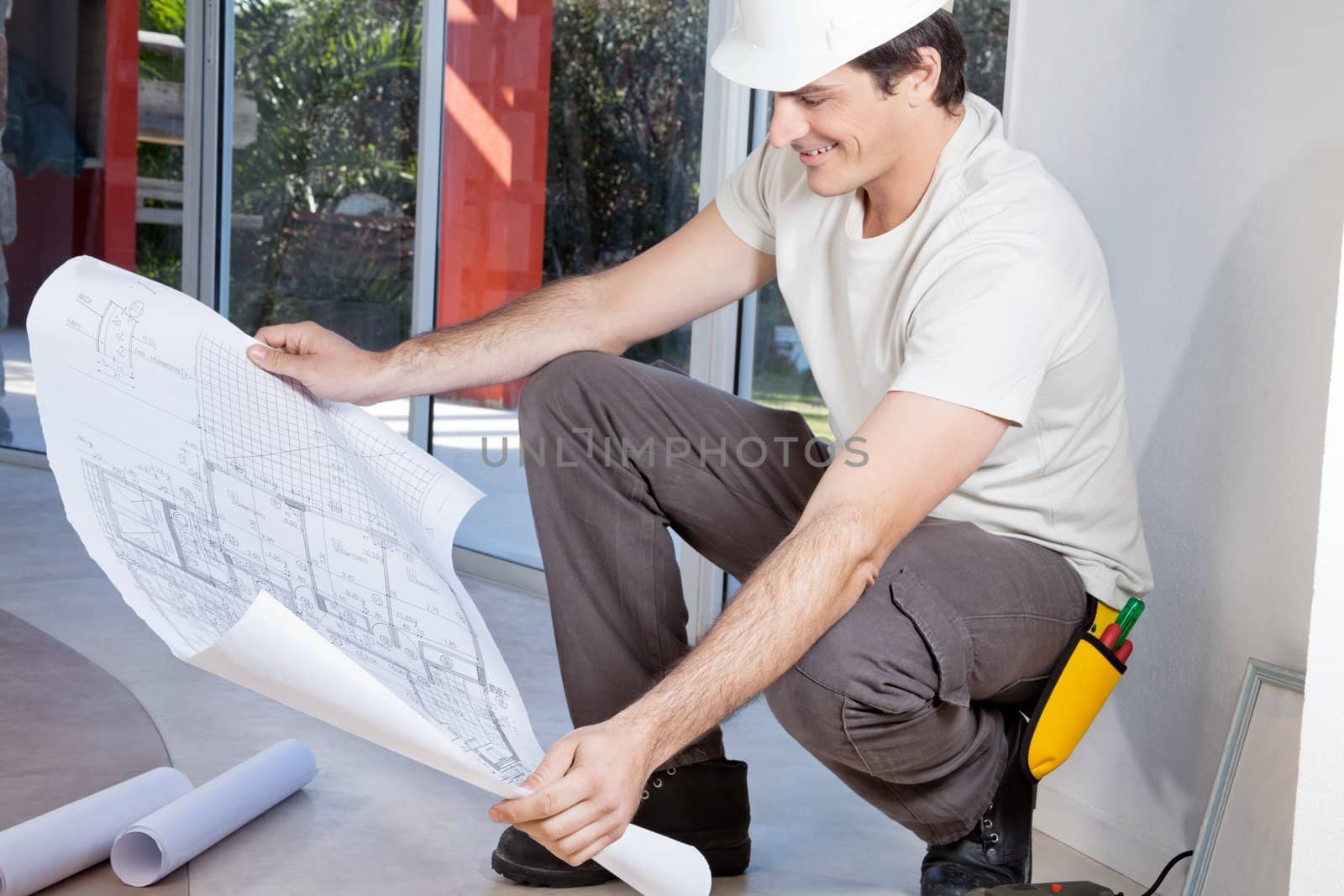 Man observing blueprint by leaf