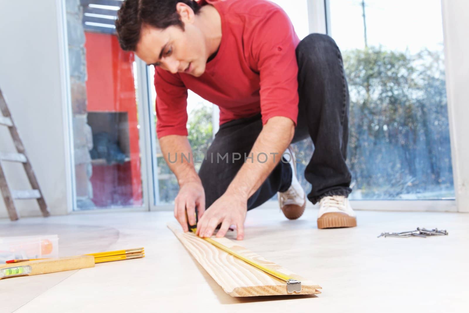 Architect measuring the wooden plank with measuring tape