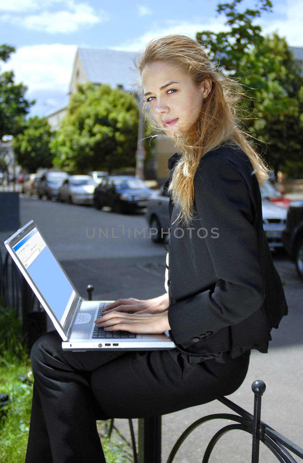 beautiful blonde happy businesswoman with laptop computer near house