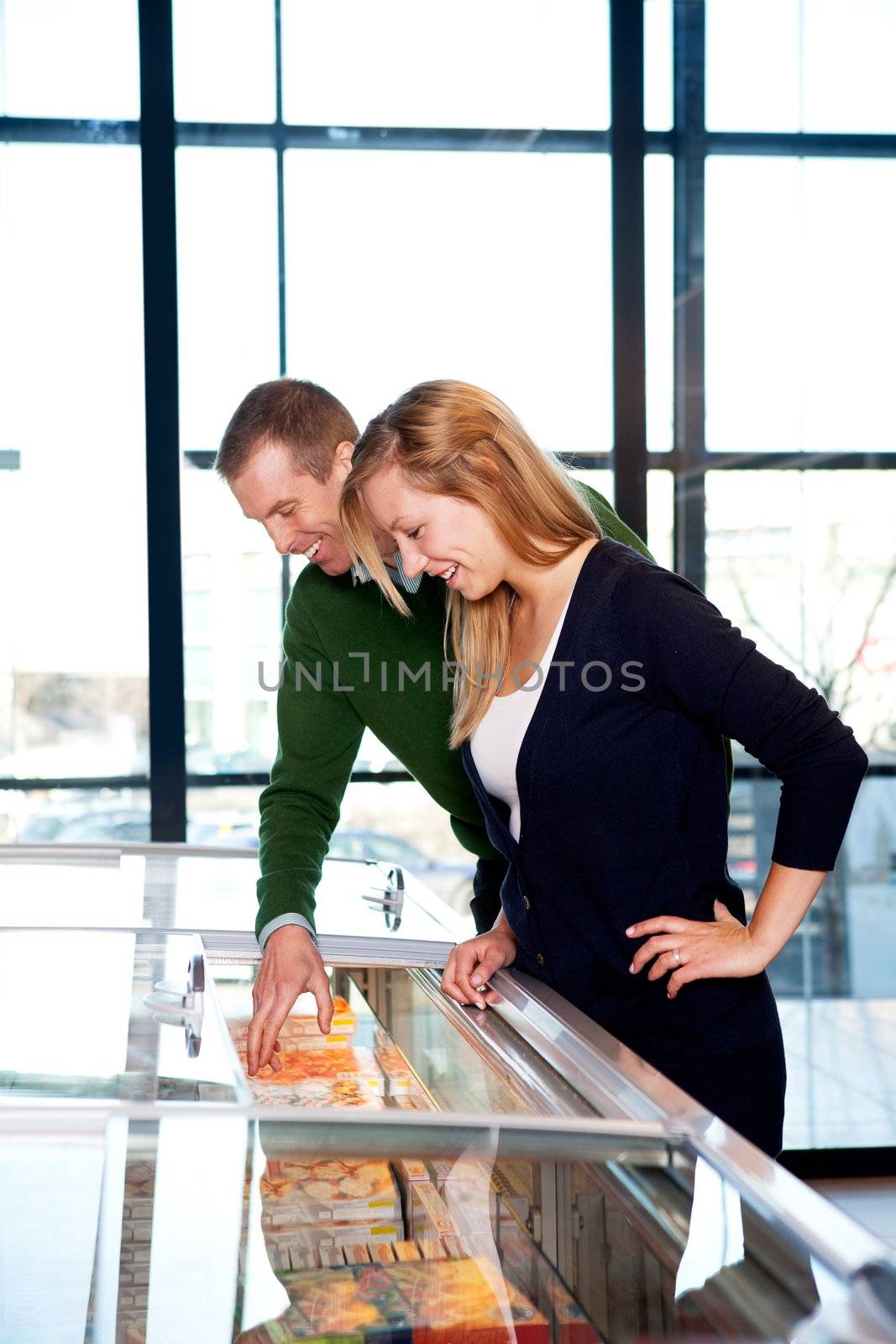 A happy couple in a supermarket buying frozen food