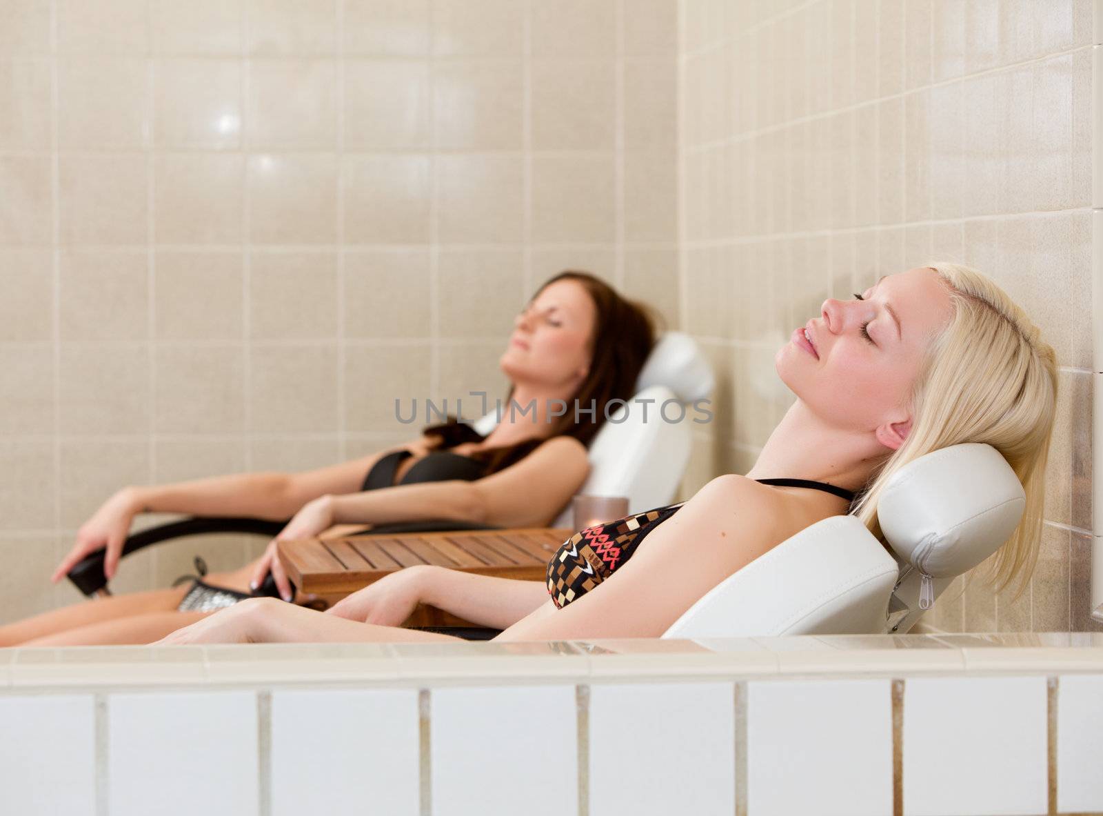 Two women relaxing at poolside in a spa