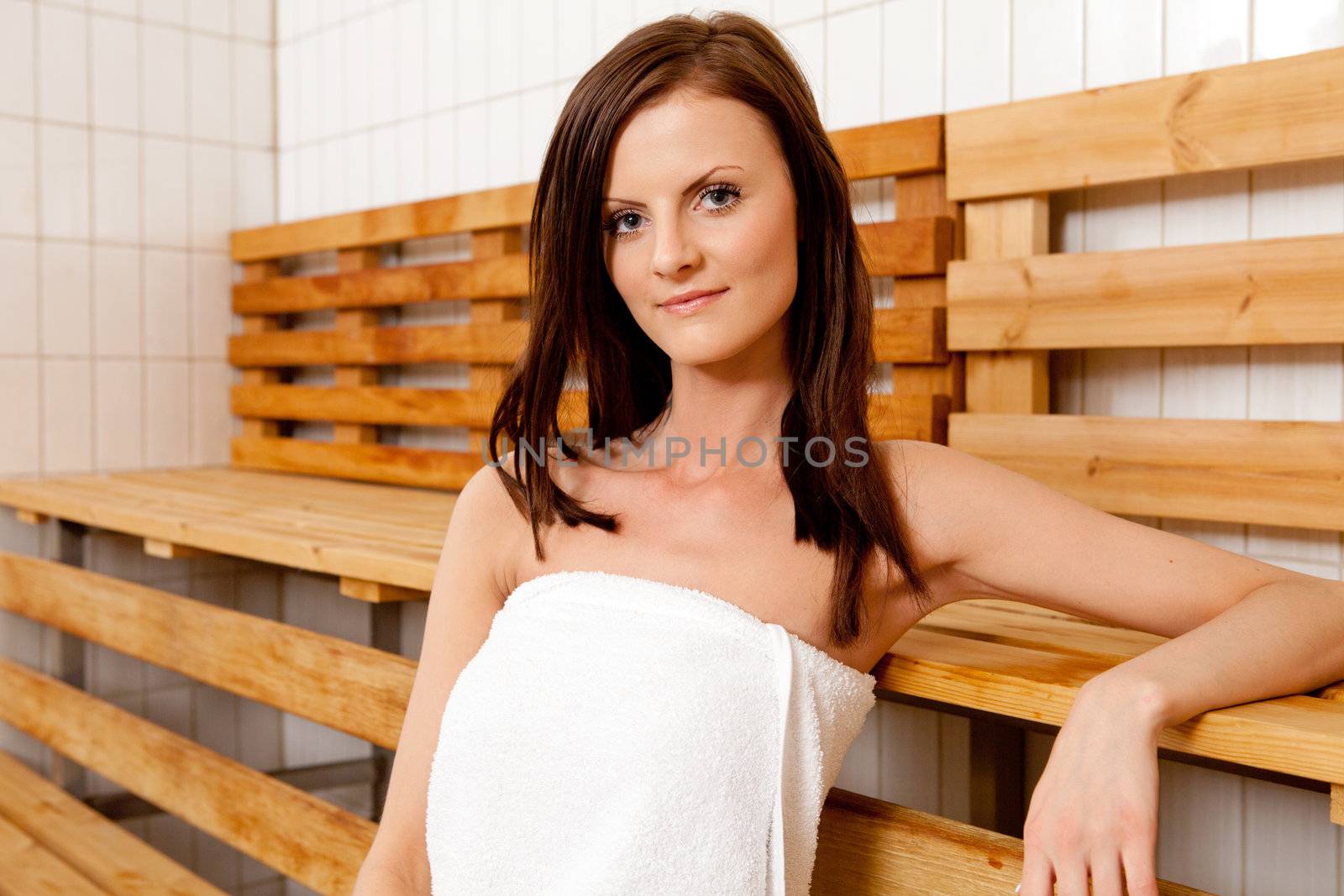 Portrait of a woman in a sauna smiling and looking at the camera