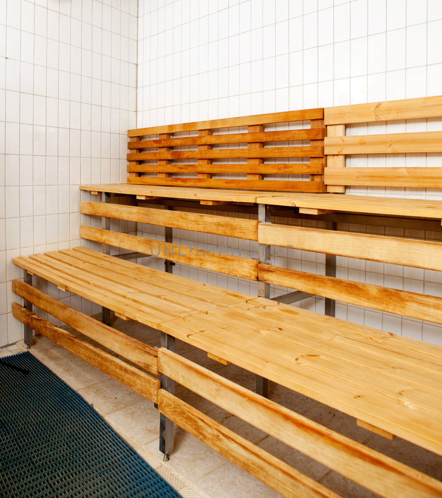 Detail of a sauna interior with tile walls and wooden benches