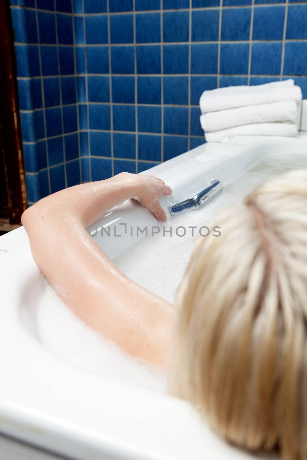 An abstract detail of a woman in a spa bath, shallow depth of field - focus on hand