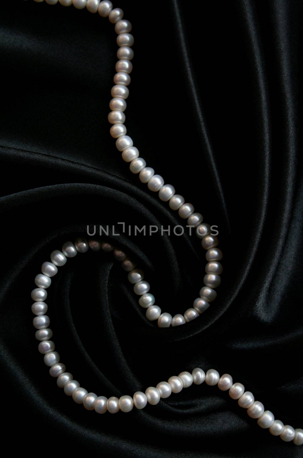 White pearls on the black velvet background 