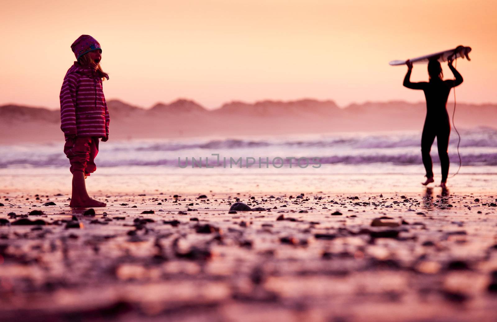 Little girl standing in the beach looking to the ocean