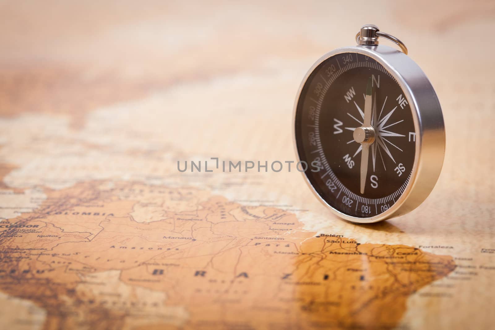A photograph with shallow depth of field of a black compass on a map, with selective focus.
