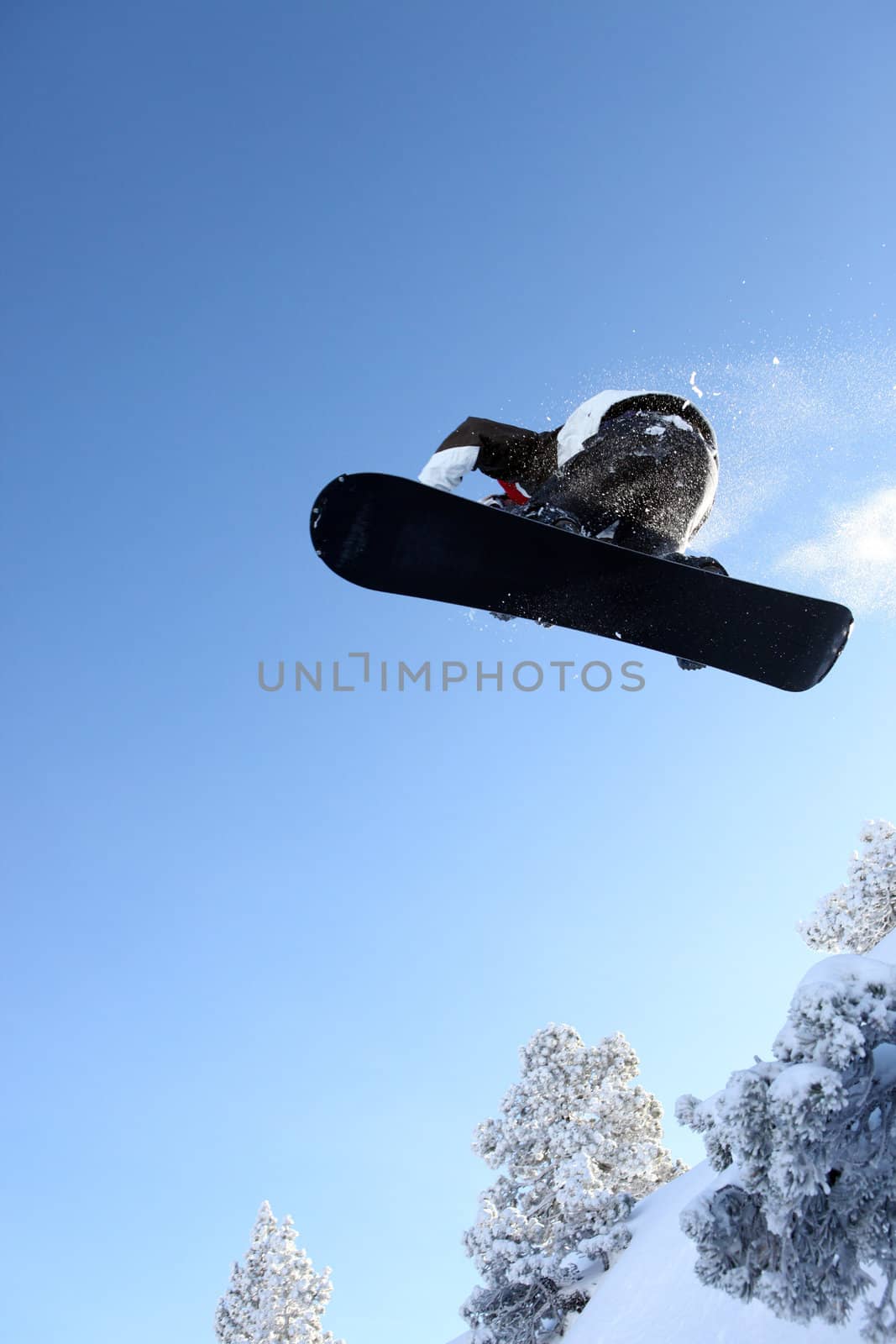 Male snowboarder performing trick by phovoir