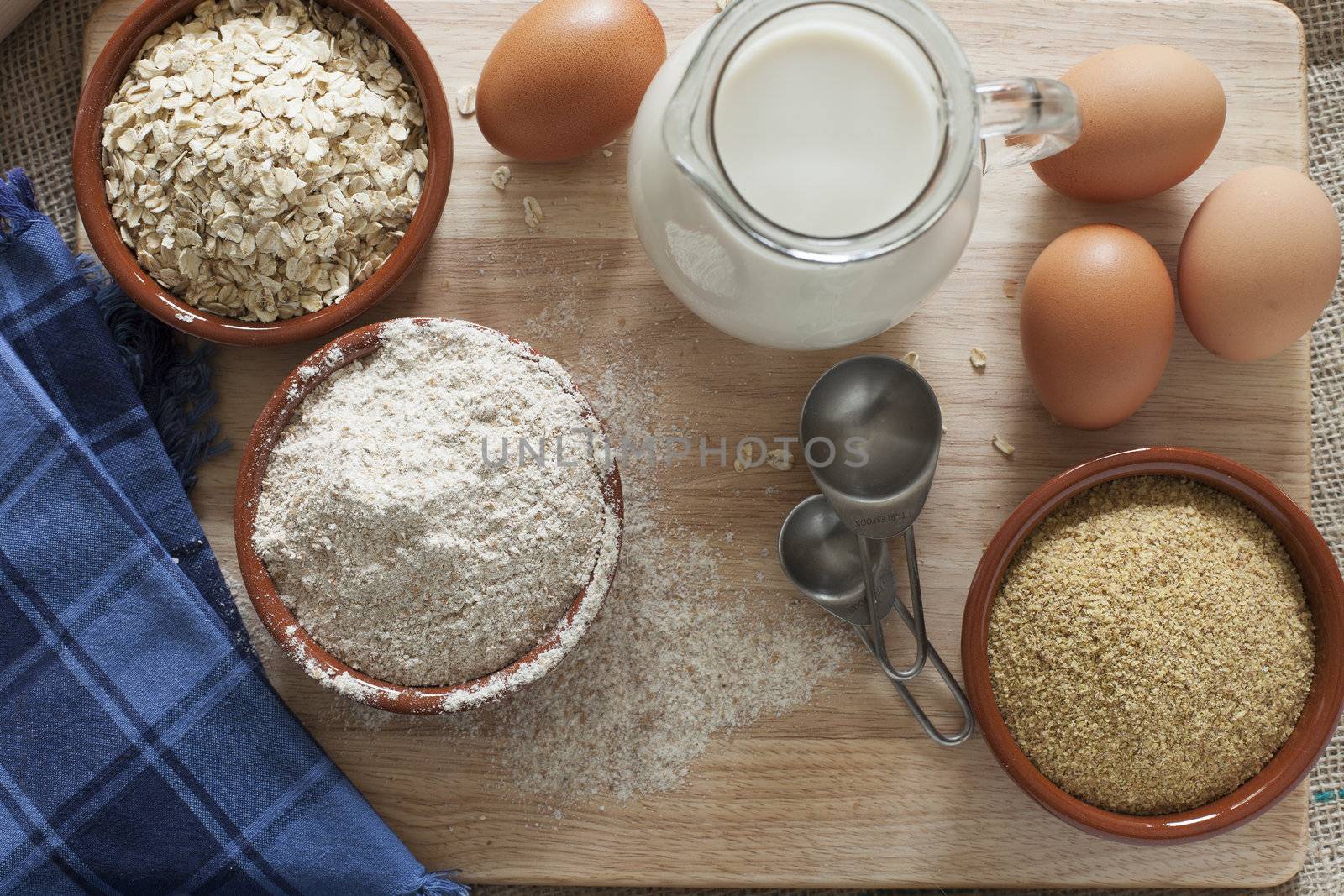 Ingredients for whole grain healthy bread, whole wheat flour, rolled oats and wheat germ with milk and eggs.