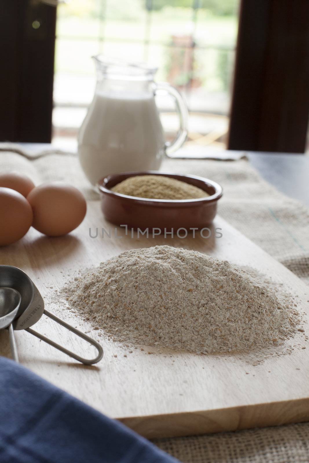 Whole wheat flour with other ingredients in background