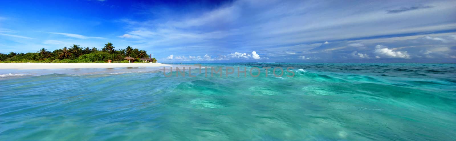 Beautiful Maldivian atoll with white beach seen from the sea - wide panoramic shot