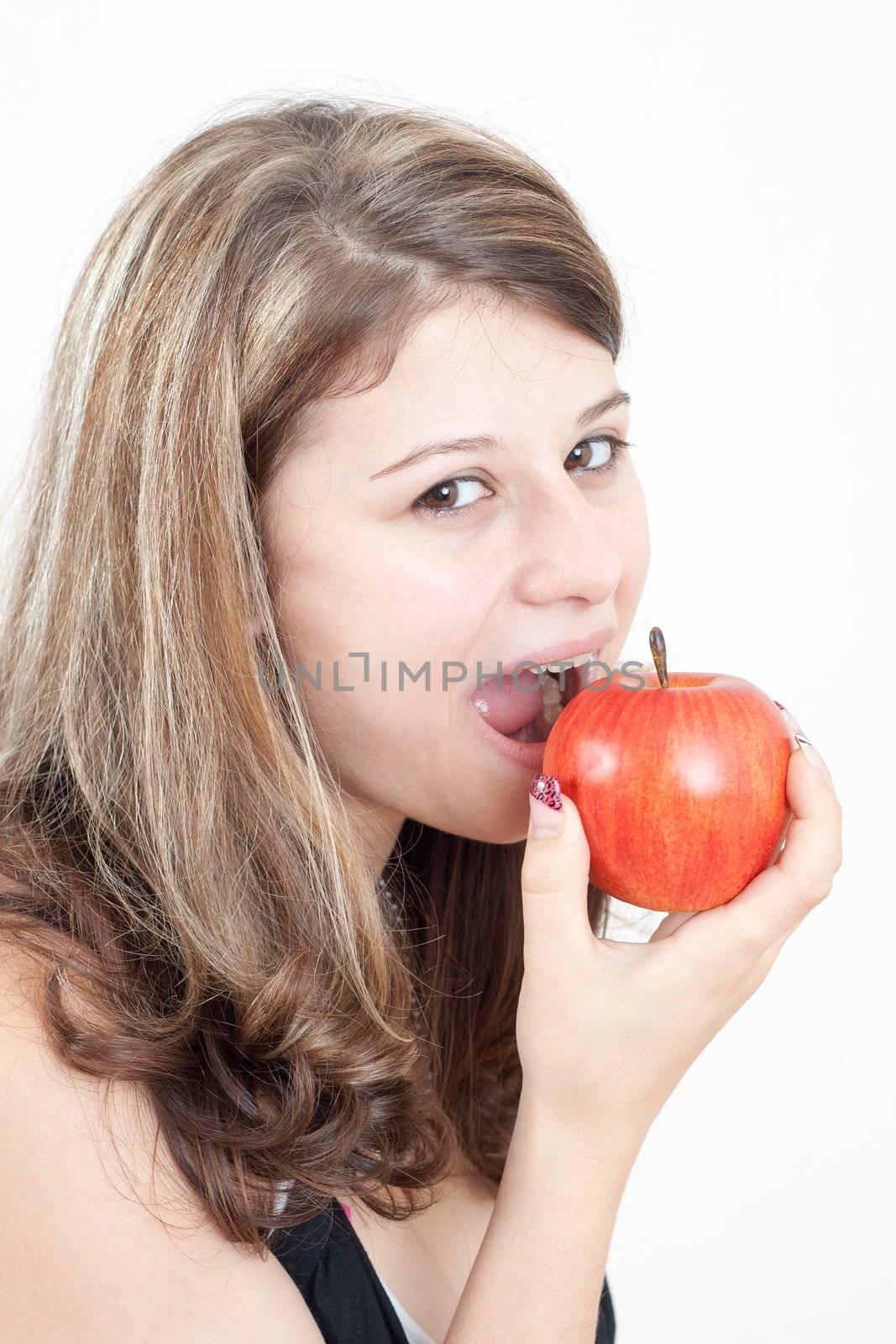 young brunette girl eating a apple on white background