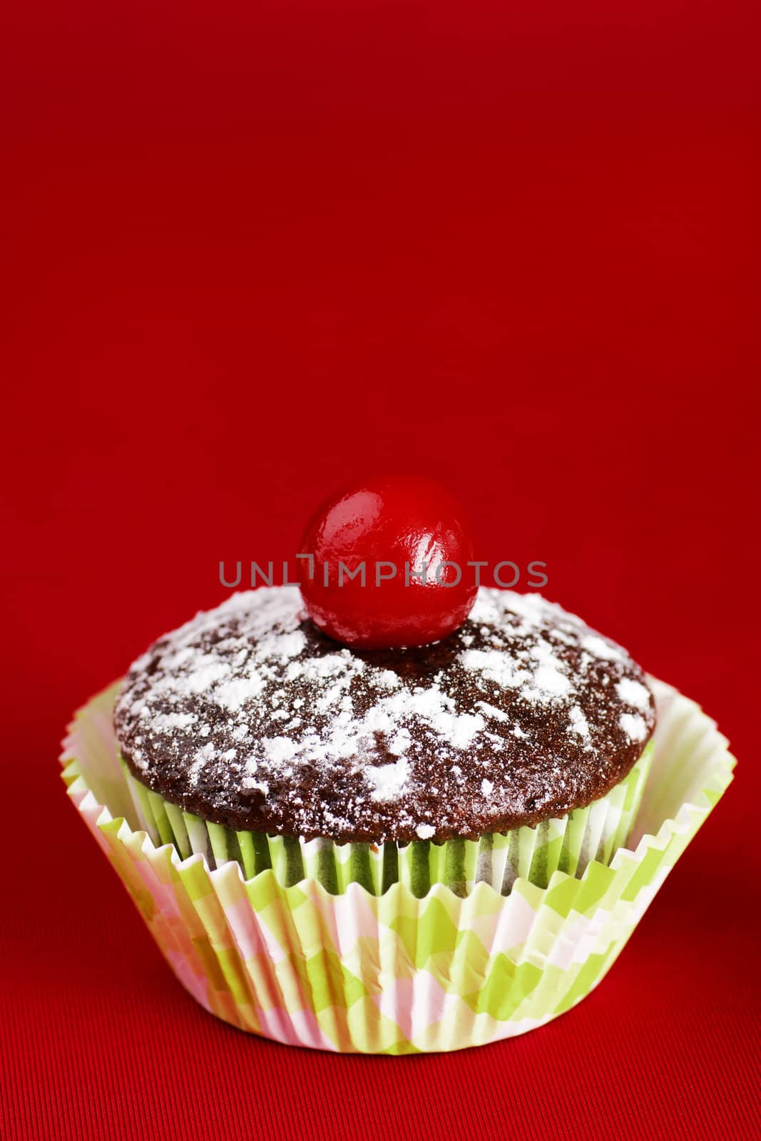 One chocolate cupcake with cherry over red by Mirage3