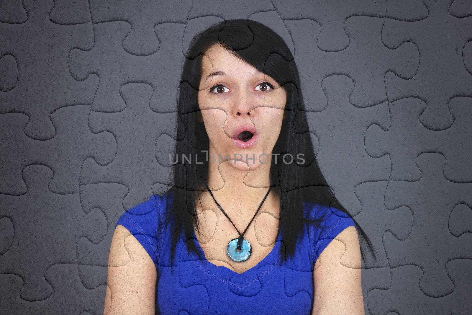 Fun concept of very surprised or puzzled young brown hair woman on jogsaw puzzle, great texture and details of the pieces.