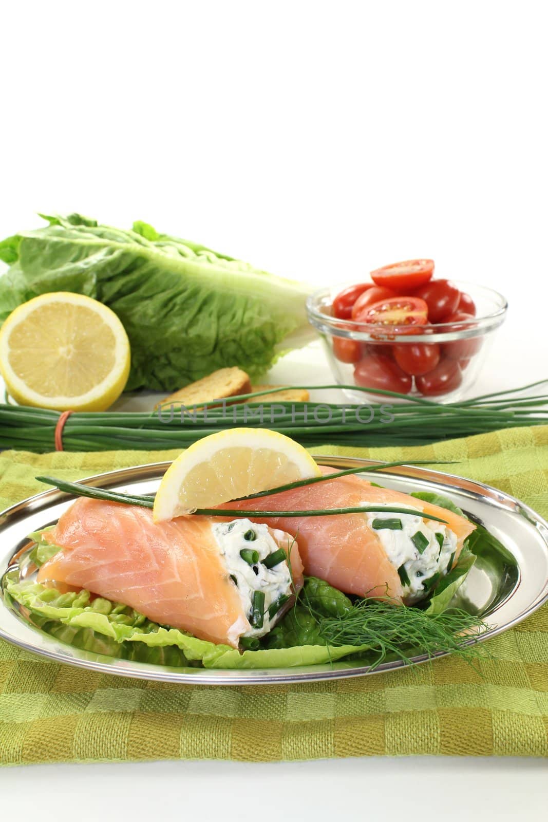 Salmon rolls with cream cheese and chives on a light background