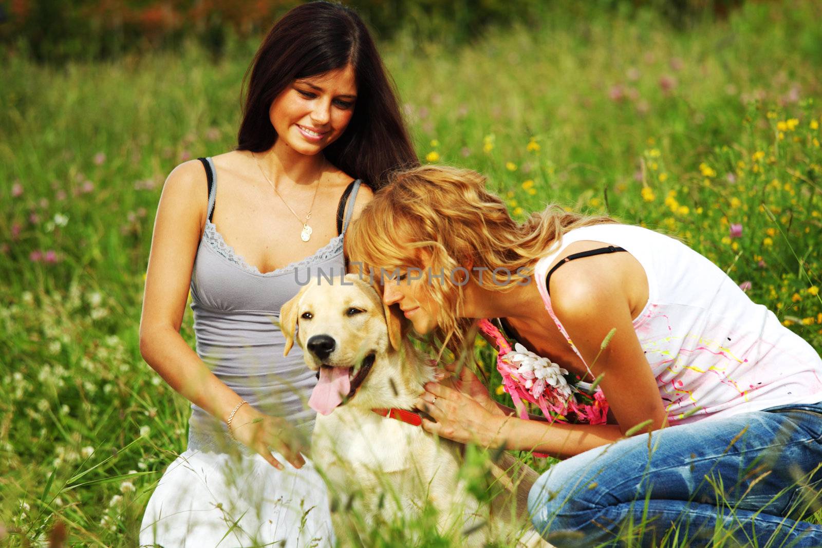 girlfriends and dog in green grass field